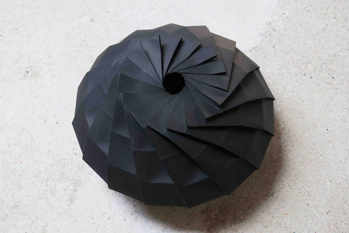 Black paper vase designed by Kristina Wißling and folded using origami techniques. For use in a trade fair booth.