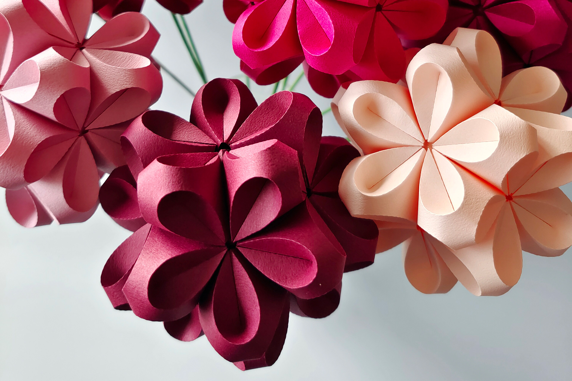 Origami Flowers in twelve shades of red. The paper flower objects are designed and handcrafted from japanese origami paper by designer Kristina Wißling.