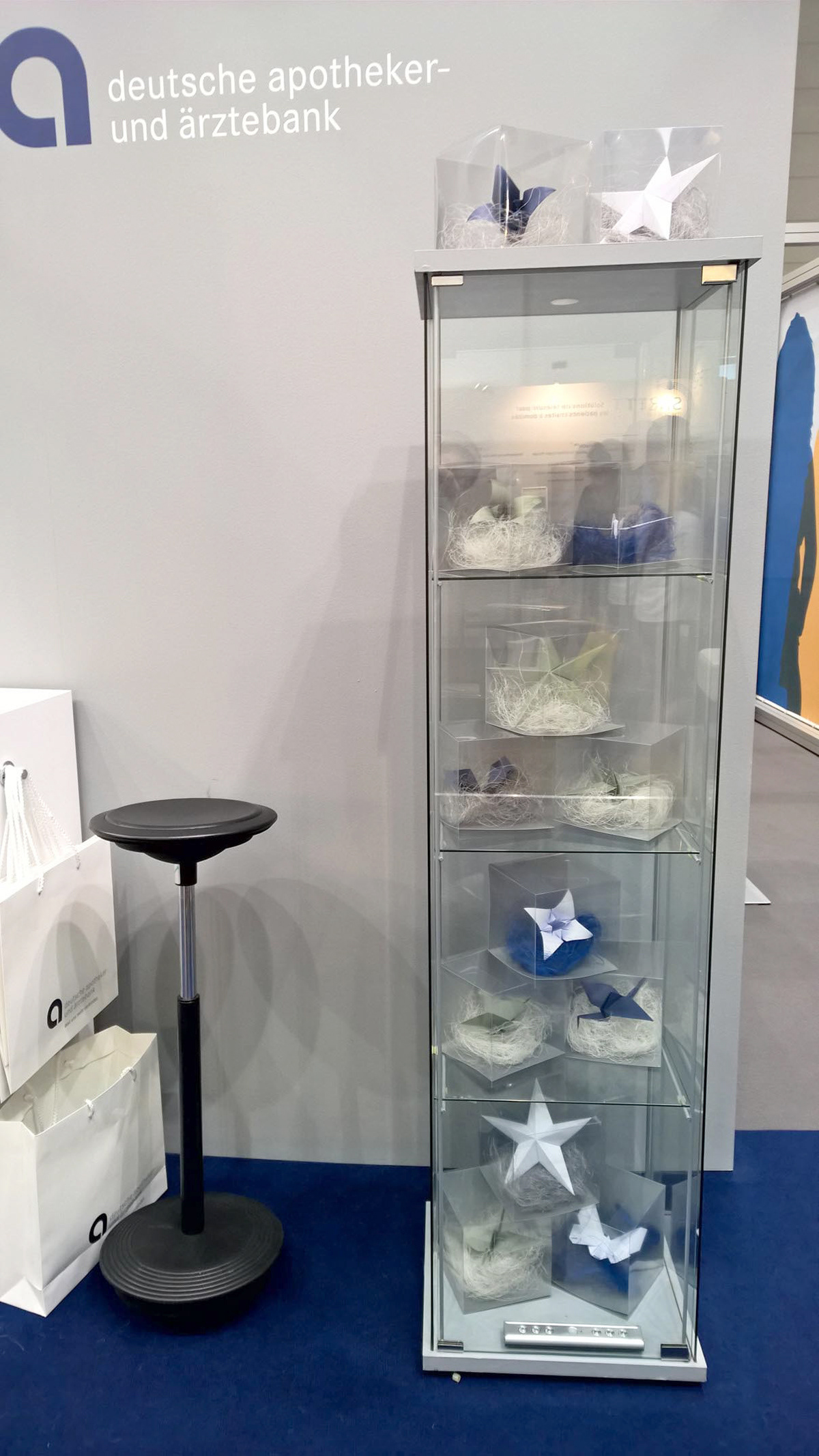 Customized origami objects with packaging in a display case as giveaways for a trade fair stand in Düsseldorf.