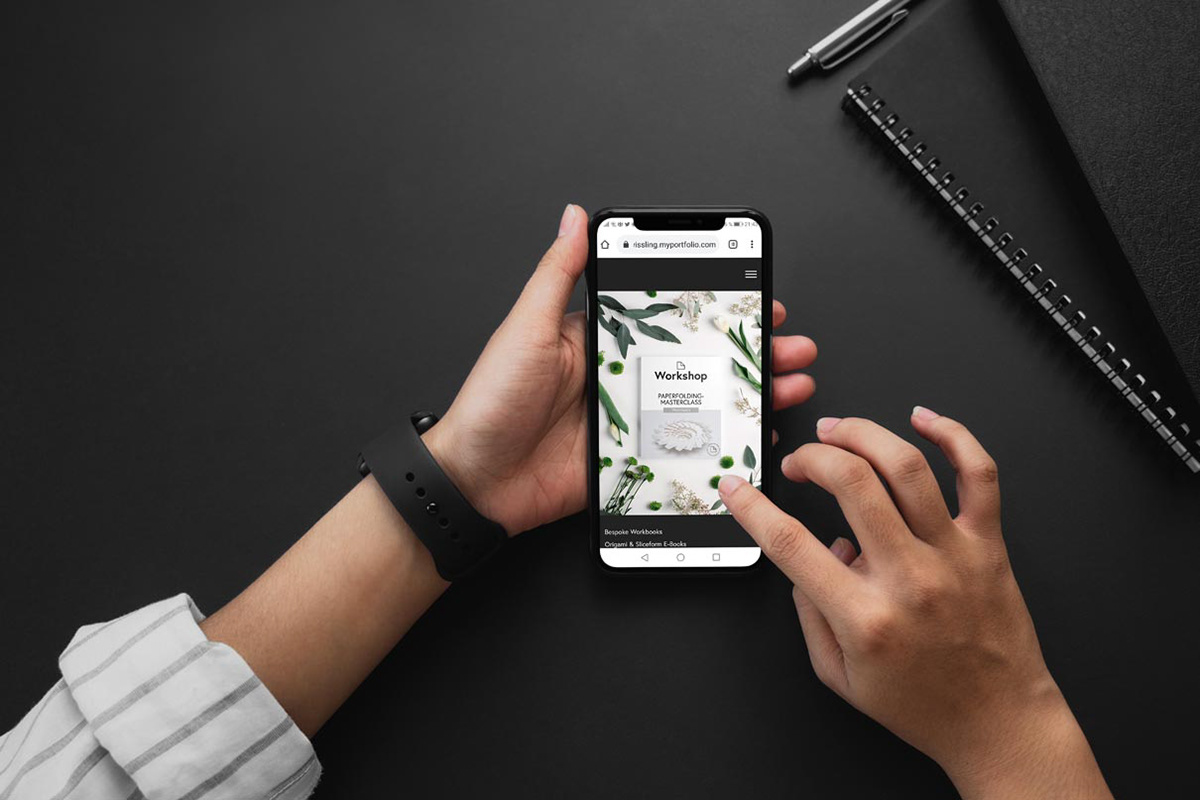 Hand with a smartphone and registration for the OrigamiDigital newsletter by Kristina Wißling.