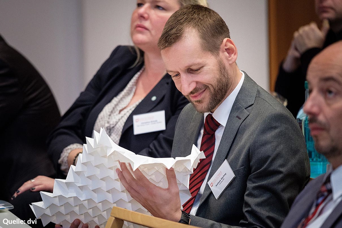 Conference participants during Kristina Wißling's presentation at the packaging conference in Dresden with a folding structure made of synthetic paper.