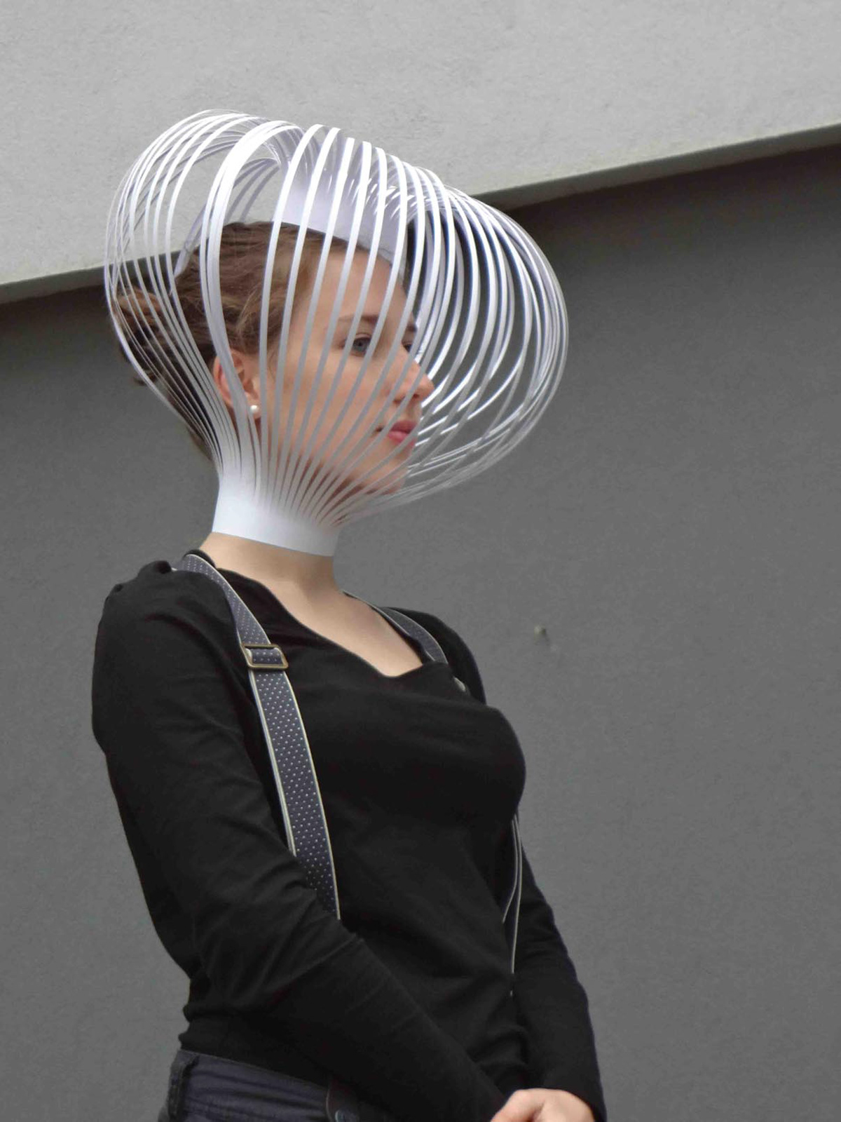 Student with a delicate head mask made of thin paper strips.