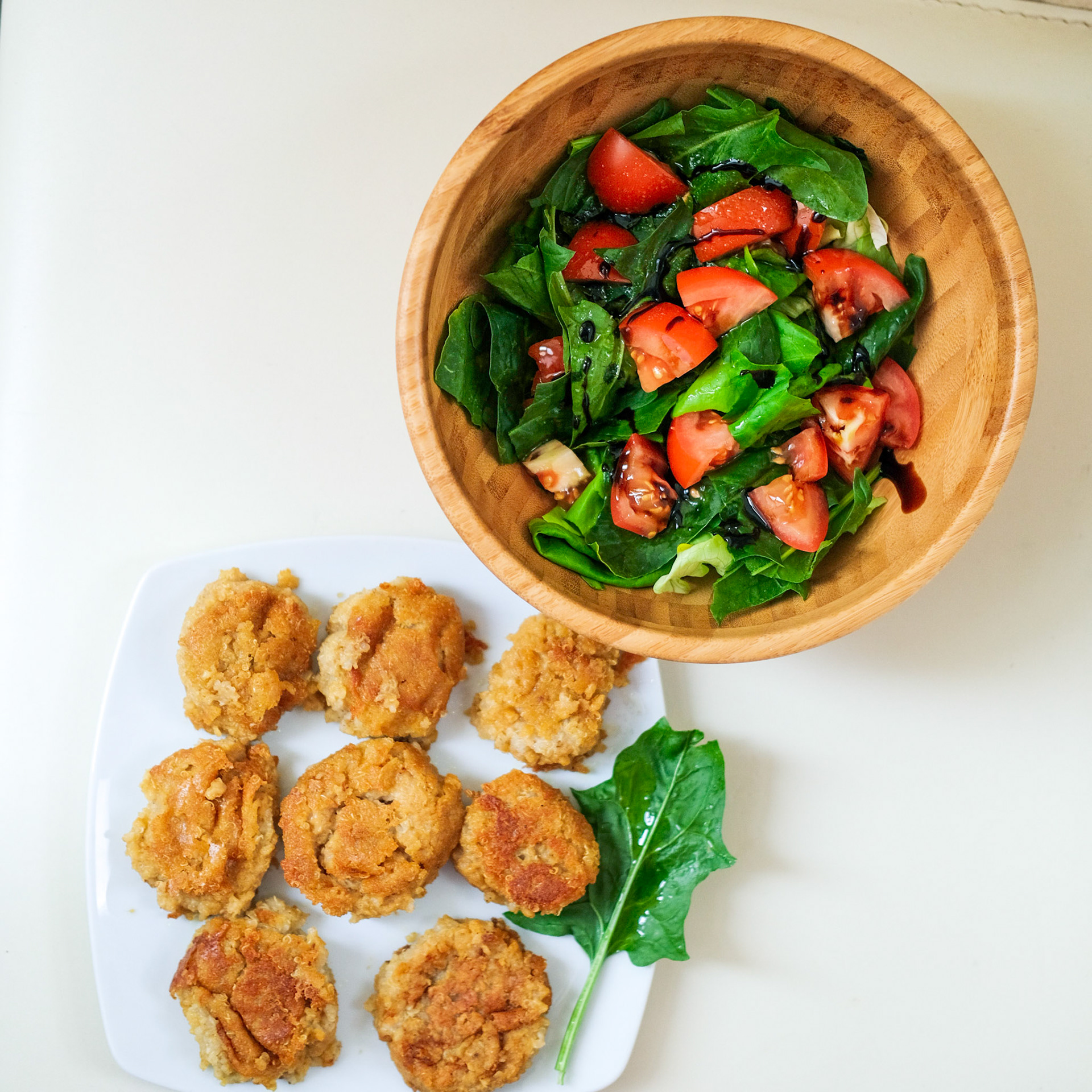 Croquetas de quinoa con ensalada de tomate y espinaca