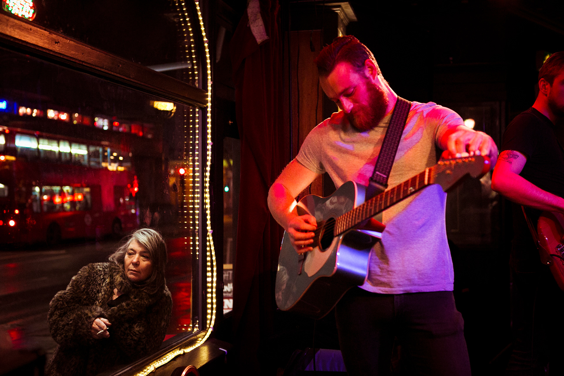 Camden London live music performance with guitarist and woman listening outside venue