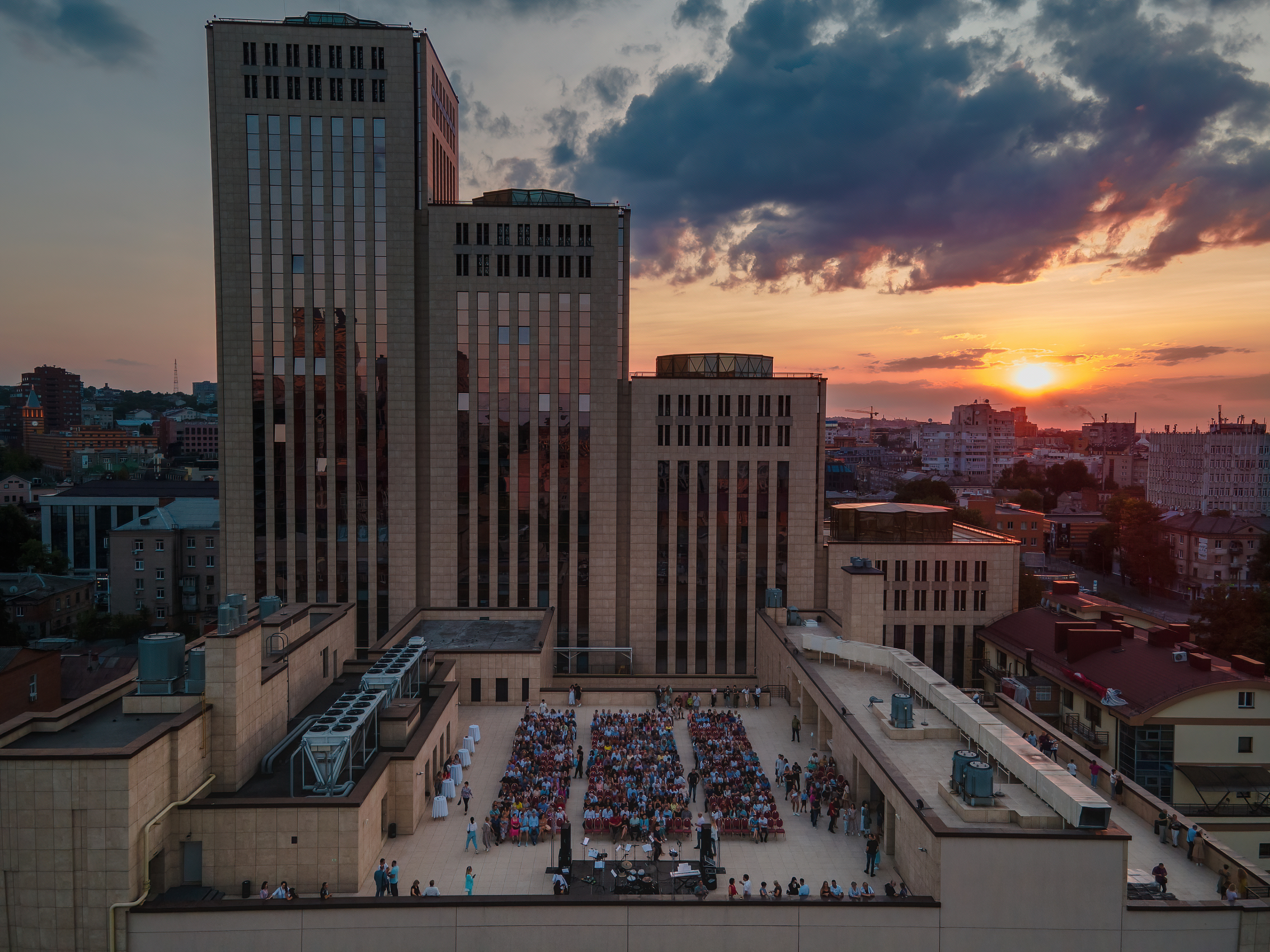 Aerial drone view of an open-air rooftop concert at the Menorah Center in Dnipro at sunset