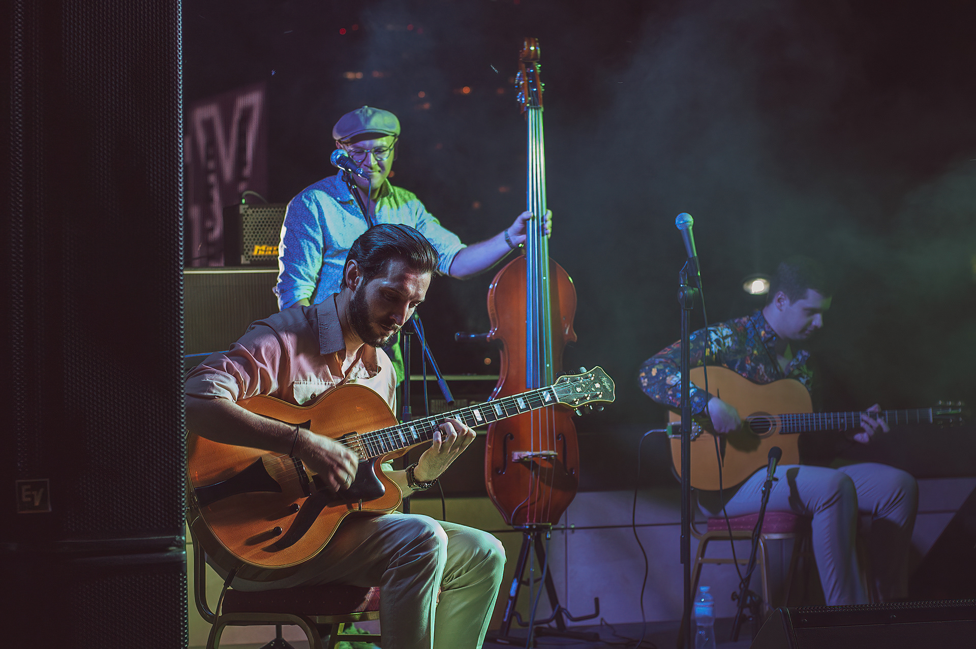 Jazz guitarist playing an archtop guitar, double bass player behind him