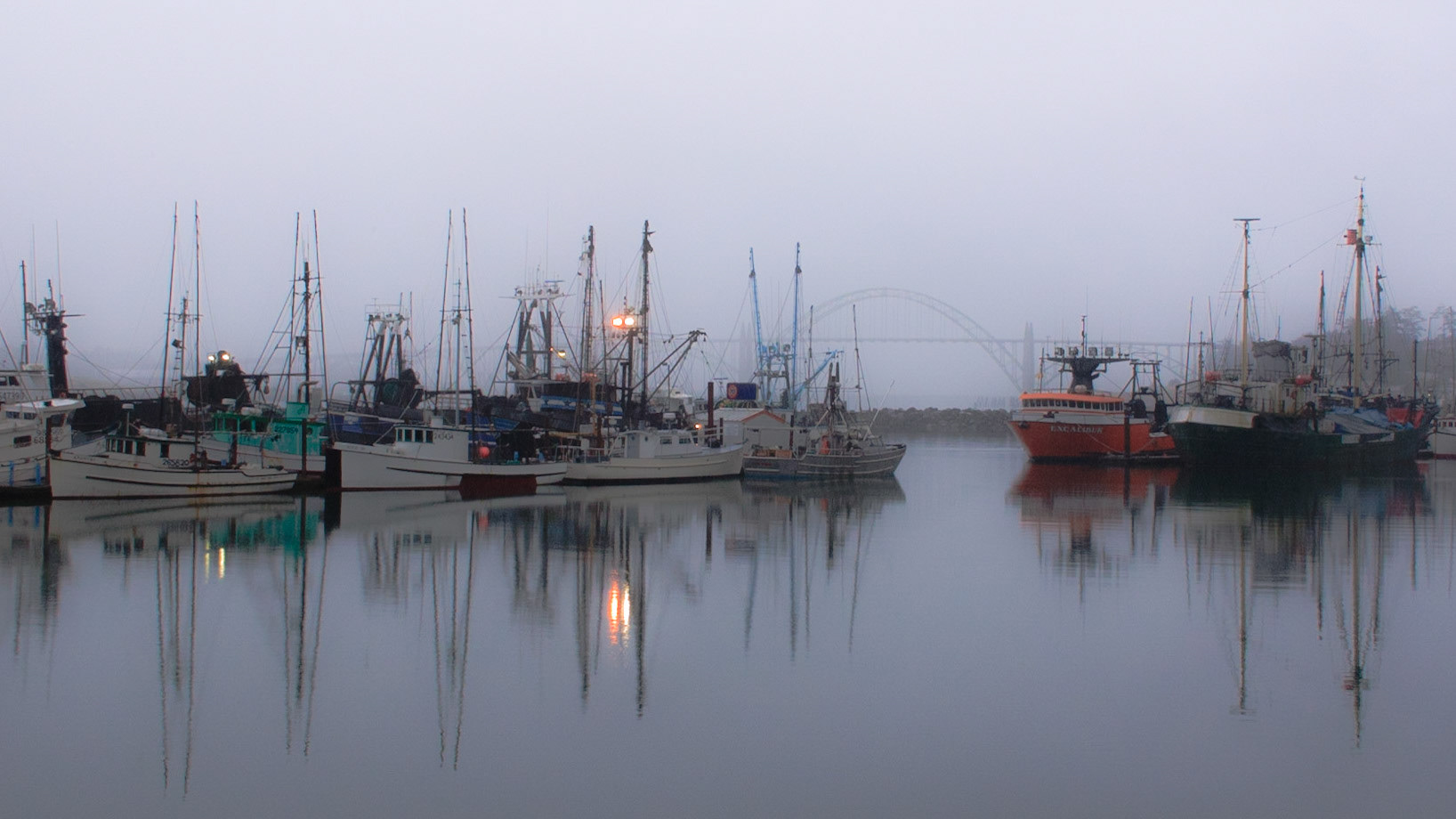 It was a typical west coast, wet gray dawn. The bridge carrying Highway 101 over Yaquina Bay frames the harbor entrance in the fog.