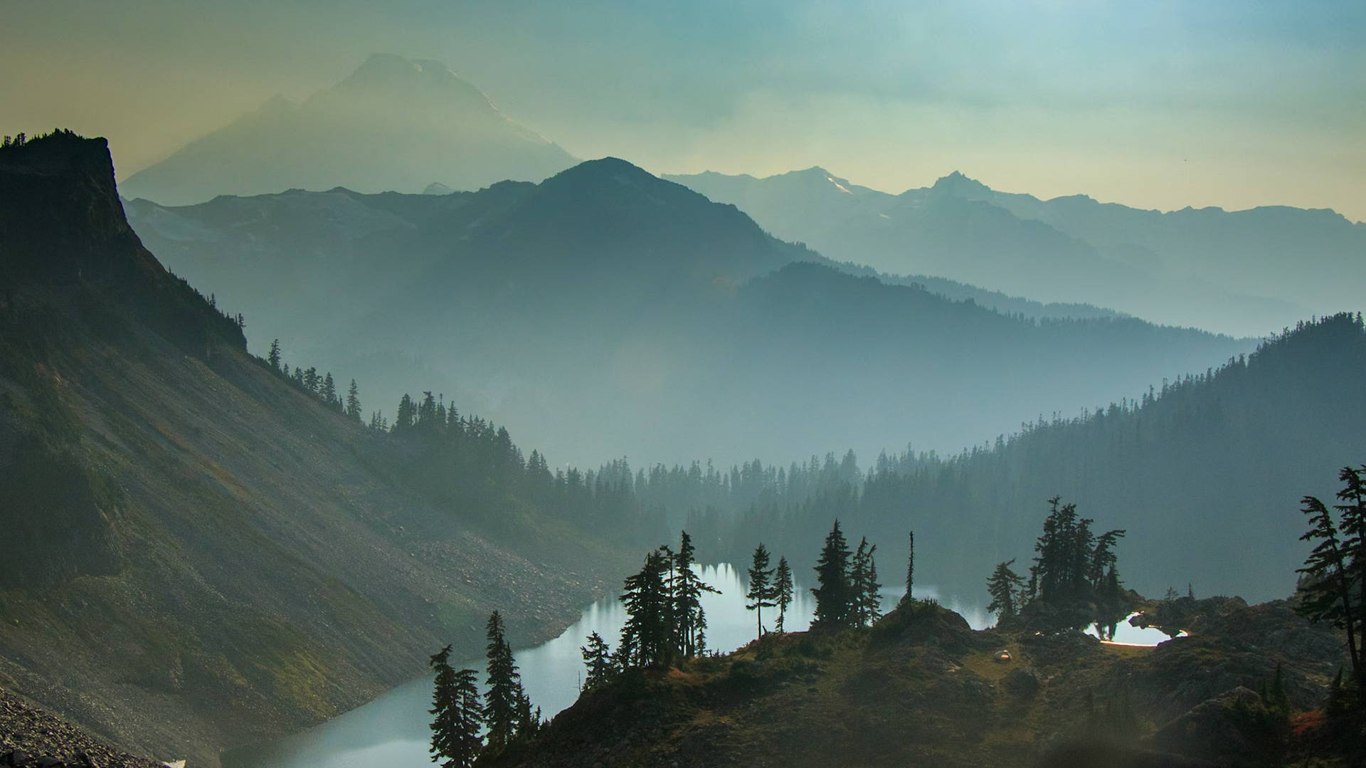 Mt Baker rises through the smoke of October wildfires. A lone campsite perches above Icicle Lake in the late afternoon sun.