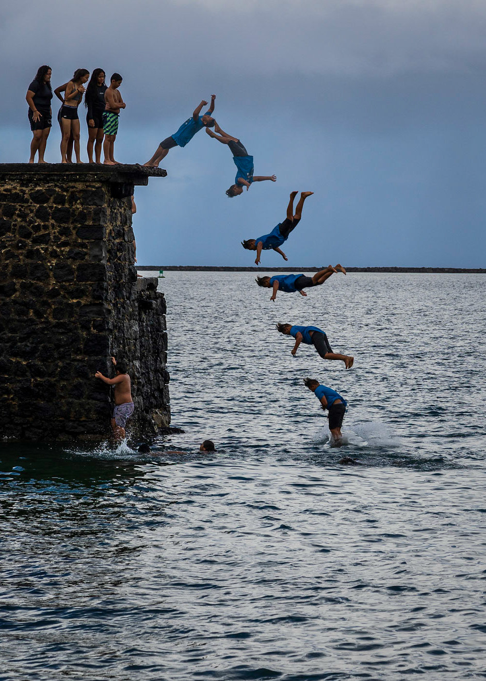 Back Flip - A group of fearless youngsters watch as their friend does a backflip off of the old pier on Coconut Island in Hilo Bay.