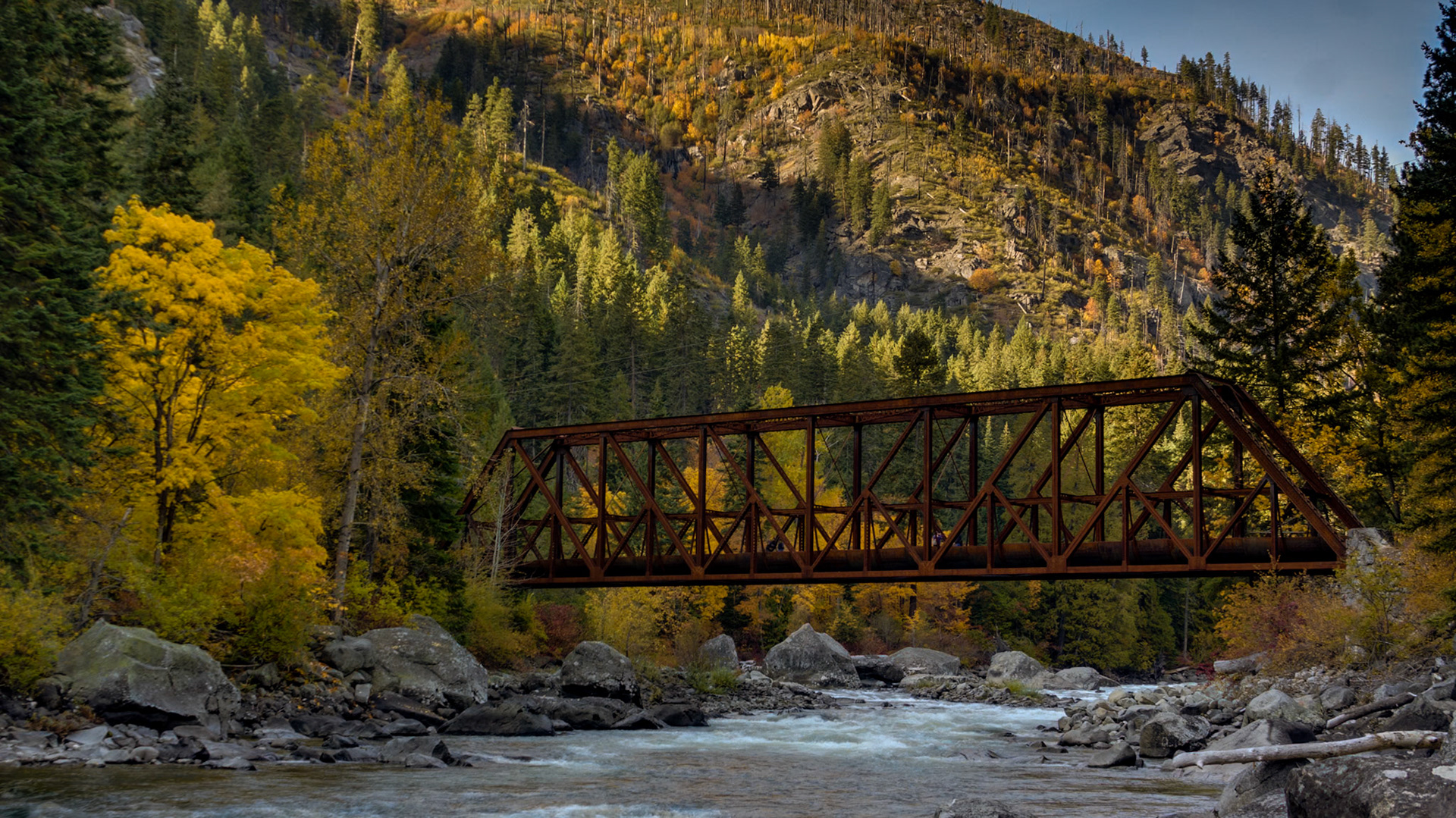 Brilliant fall colors frame this old steel trestle over the Wenatchee River west of Leavenworth, WA