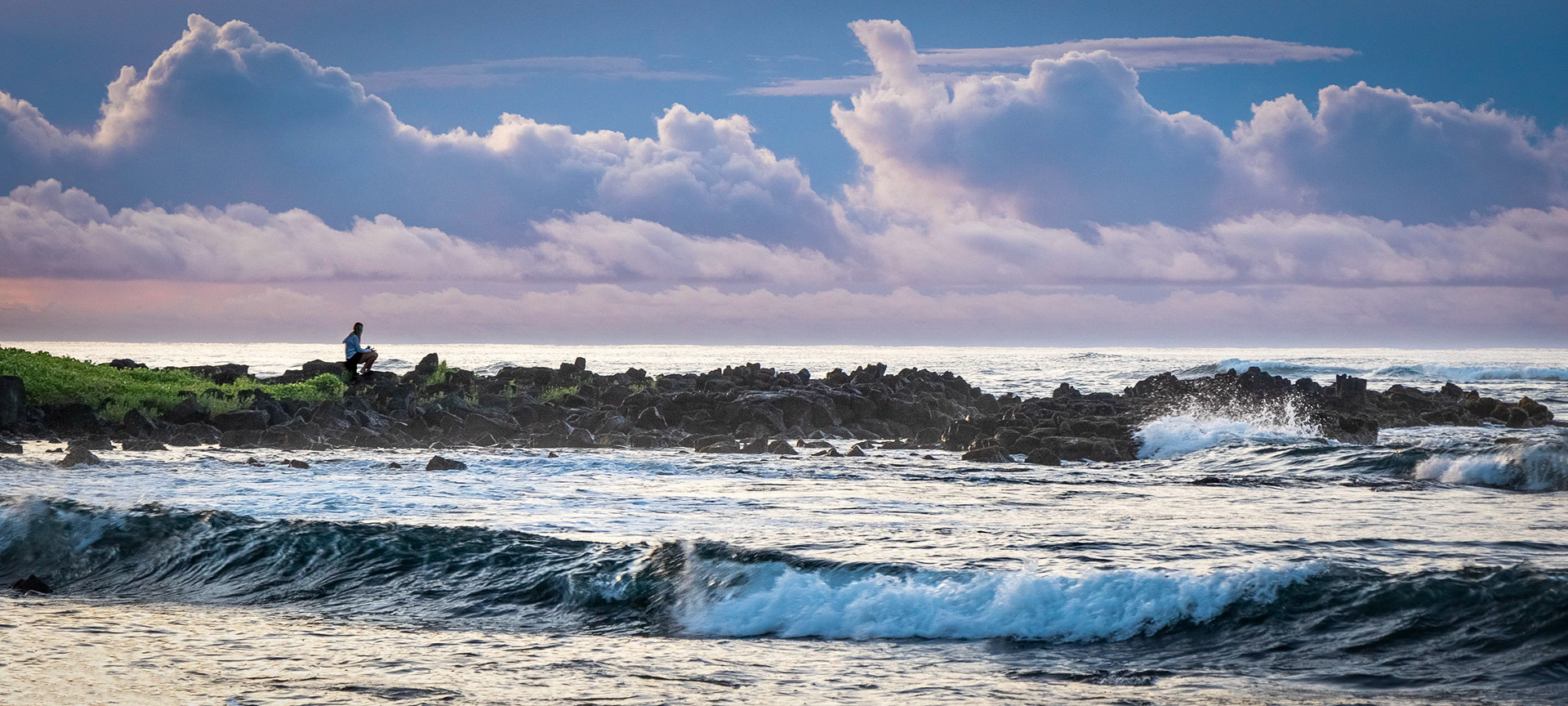 A young lady enjoys her morning coffee while watching the ocean swells