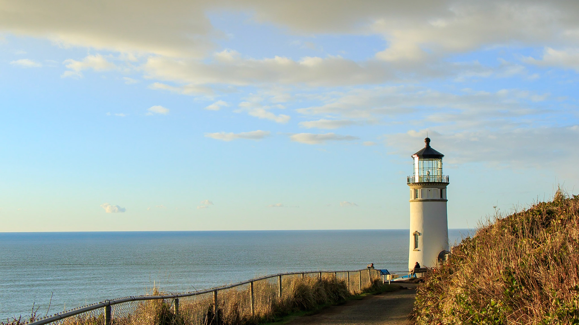 North Head Lighthouse stands above a calm North Pacific Ocean in the early evening