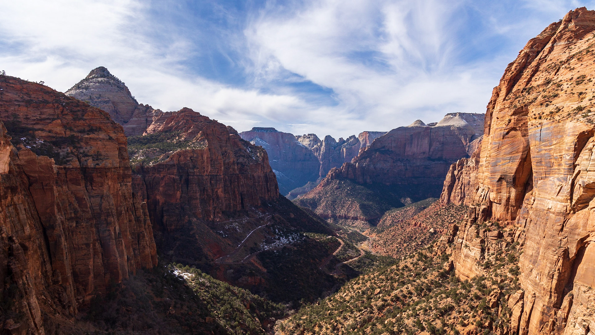 Looking west from atop the Grand Arch at Zion National Park. The highway zig-zags its way up to the Mt Carmel Tunnel which was carved into the mountain on the left of the canyon.
