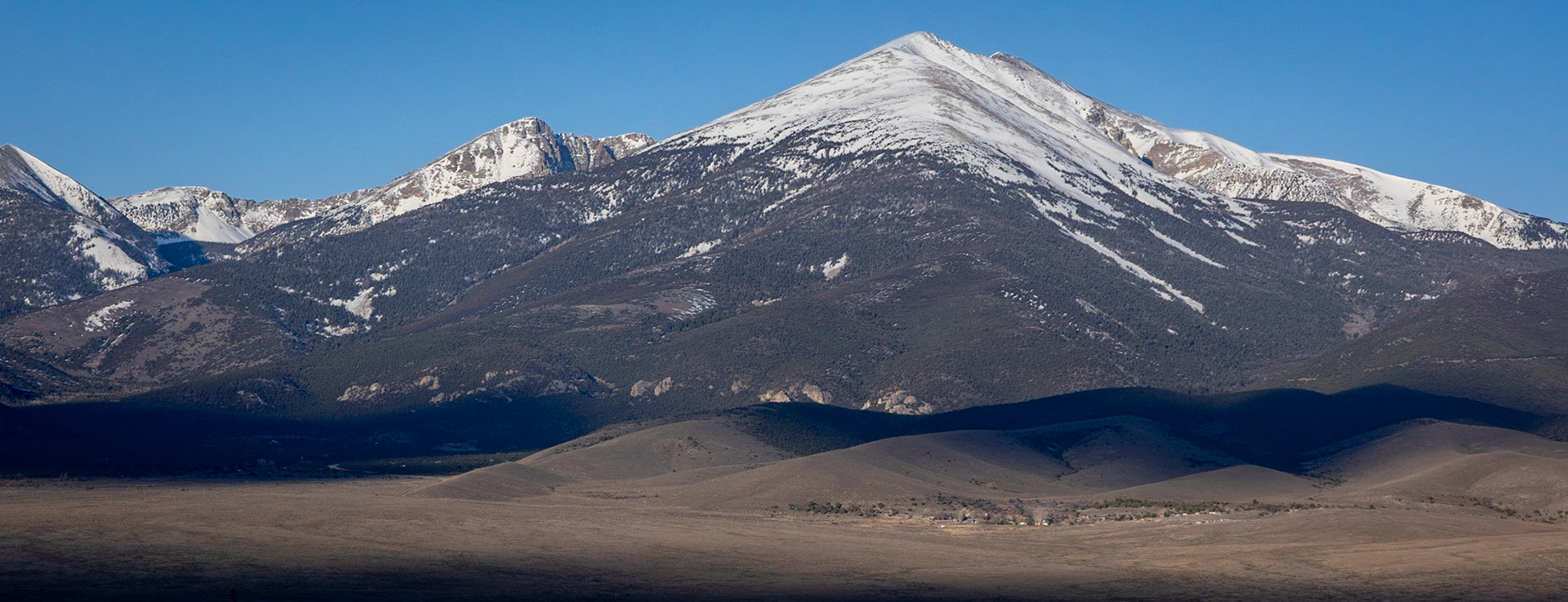 On my way home from Utah in April I followed US 50. The highway passes Great Basin National Park. You enter it on the east side of Mt Wheeler through Baker.I found this composition with the town (village) of Baker nestled between the "roots" of Mt Wheeler to be quite compelling. To me it captures the feel for the area. It certainly didn't hurt to have some clouds provide a mask to highlight the town.