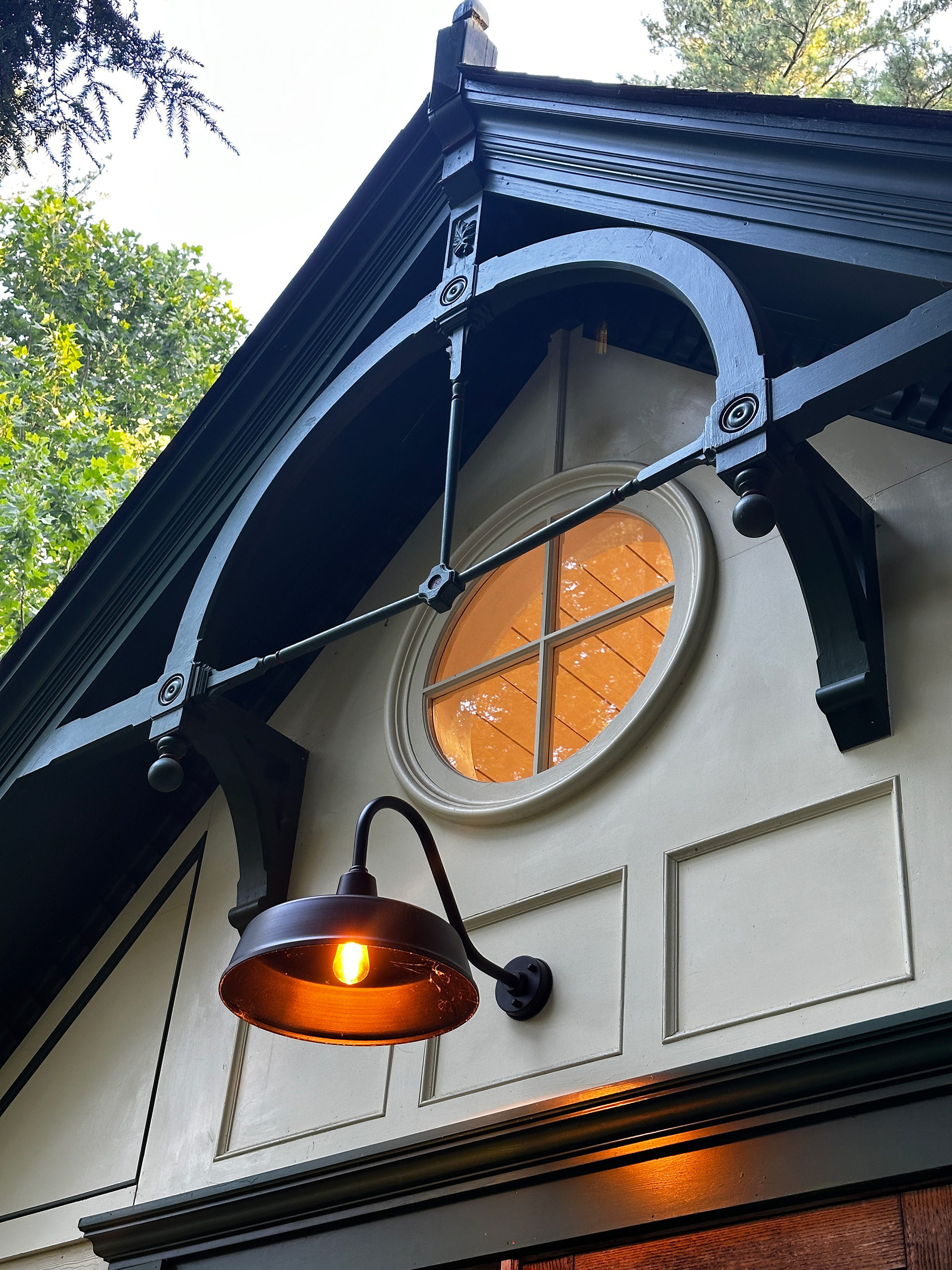 Round window, Victorian-inspired woodwork and exterior details of Catskill River Cottage.