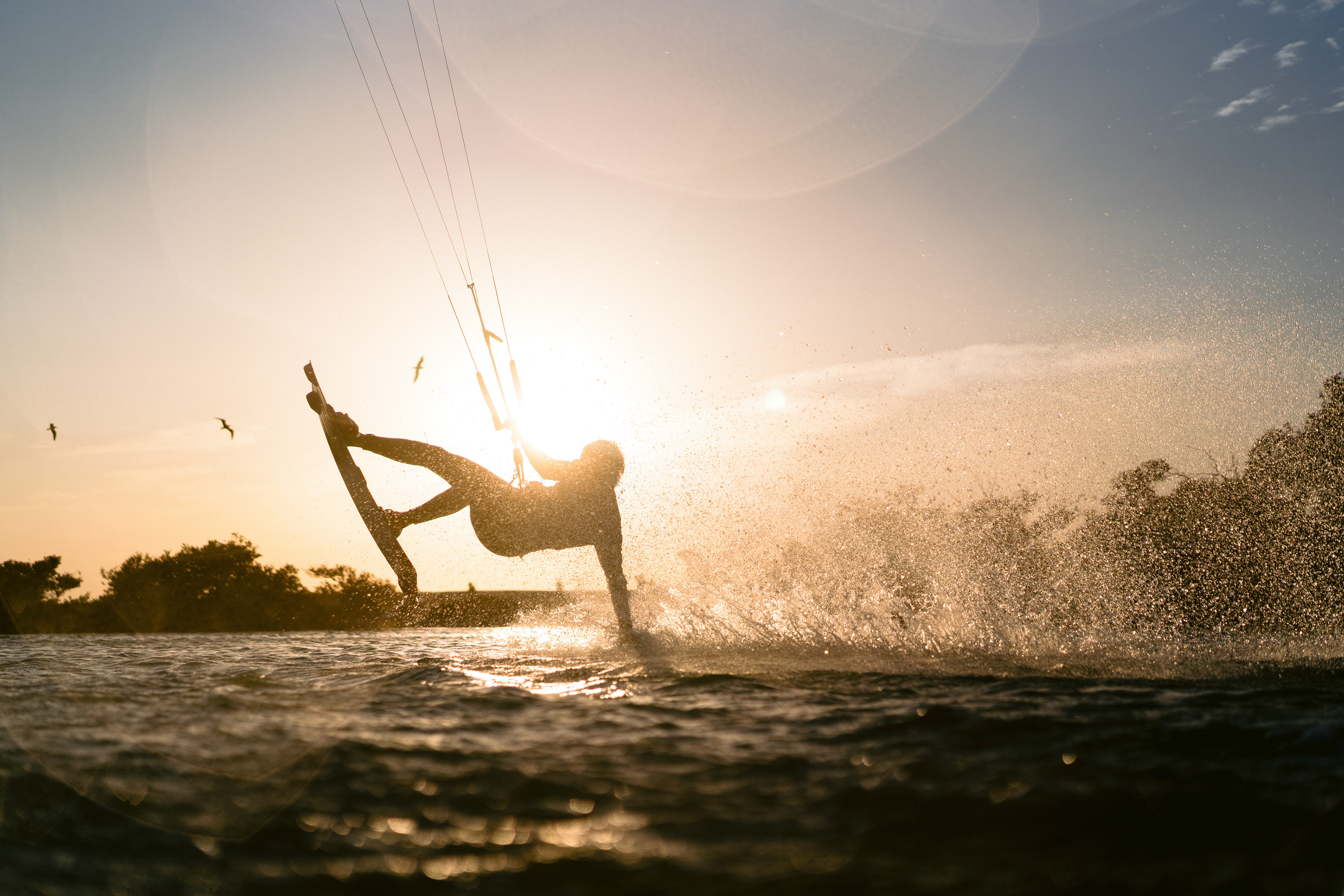 Kitesurfer riding at sunset