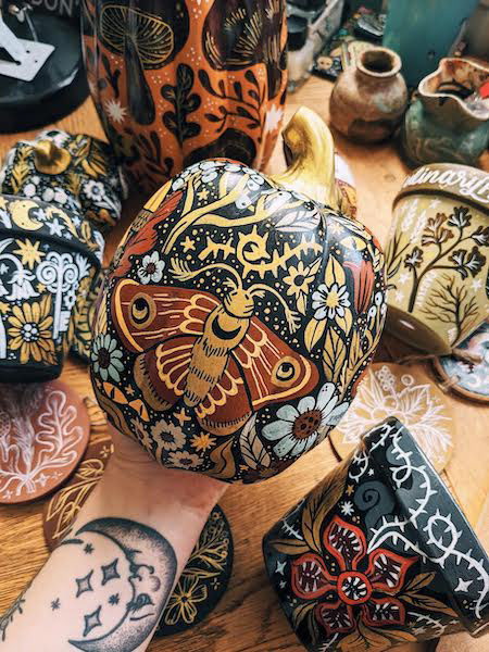 a close up of a hand painted ceramic pumpkin, painted in rich autumn colours
