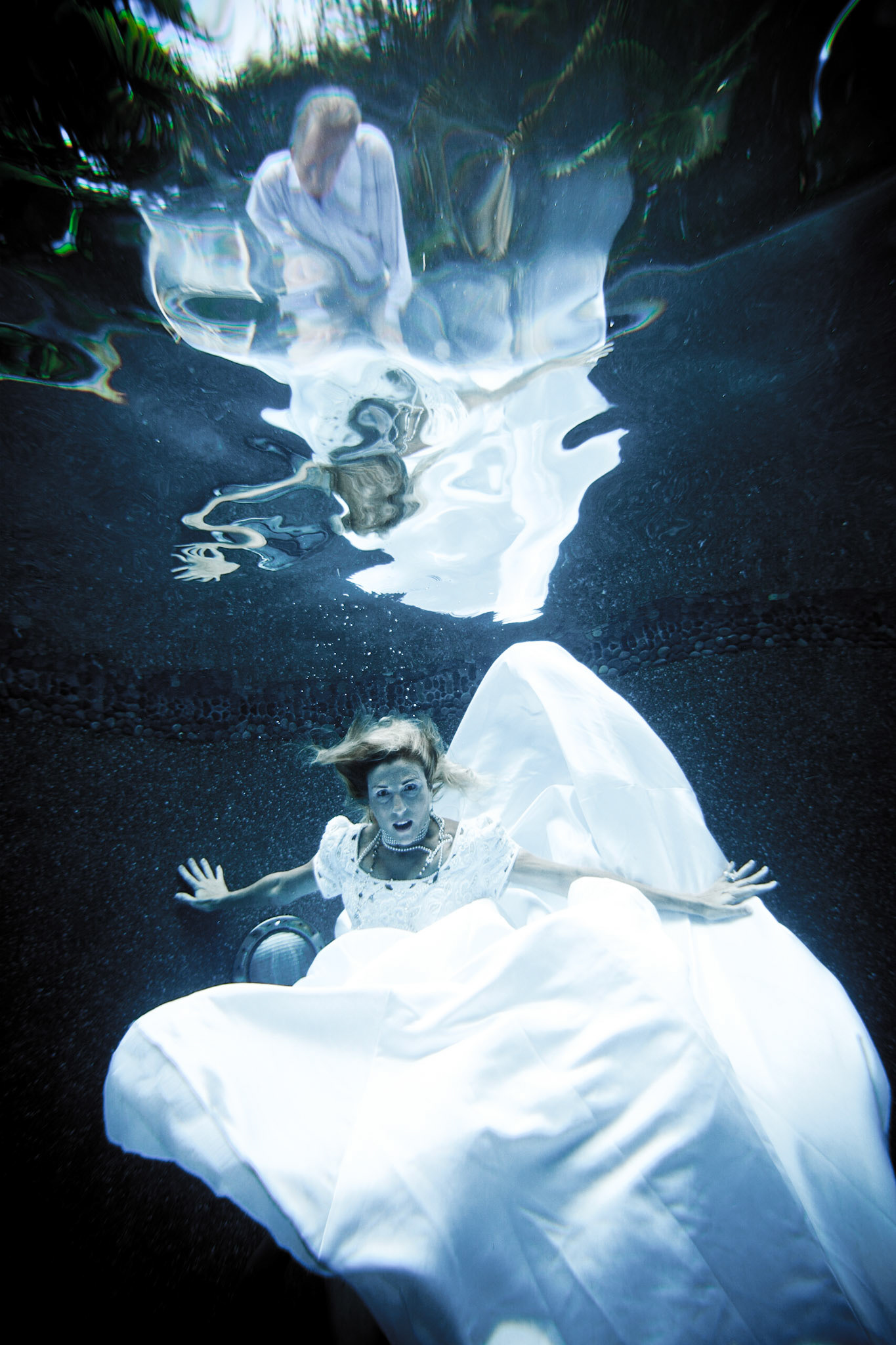 7918-Bridal art trash the dress style.Helen in her wedding dress taking the plunge. We took these images in Helen's pool, love the dark finish. In all of these images both the model and photographer are underwater.