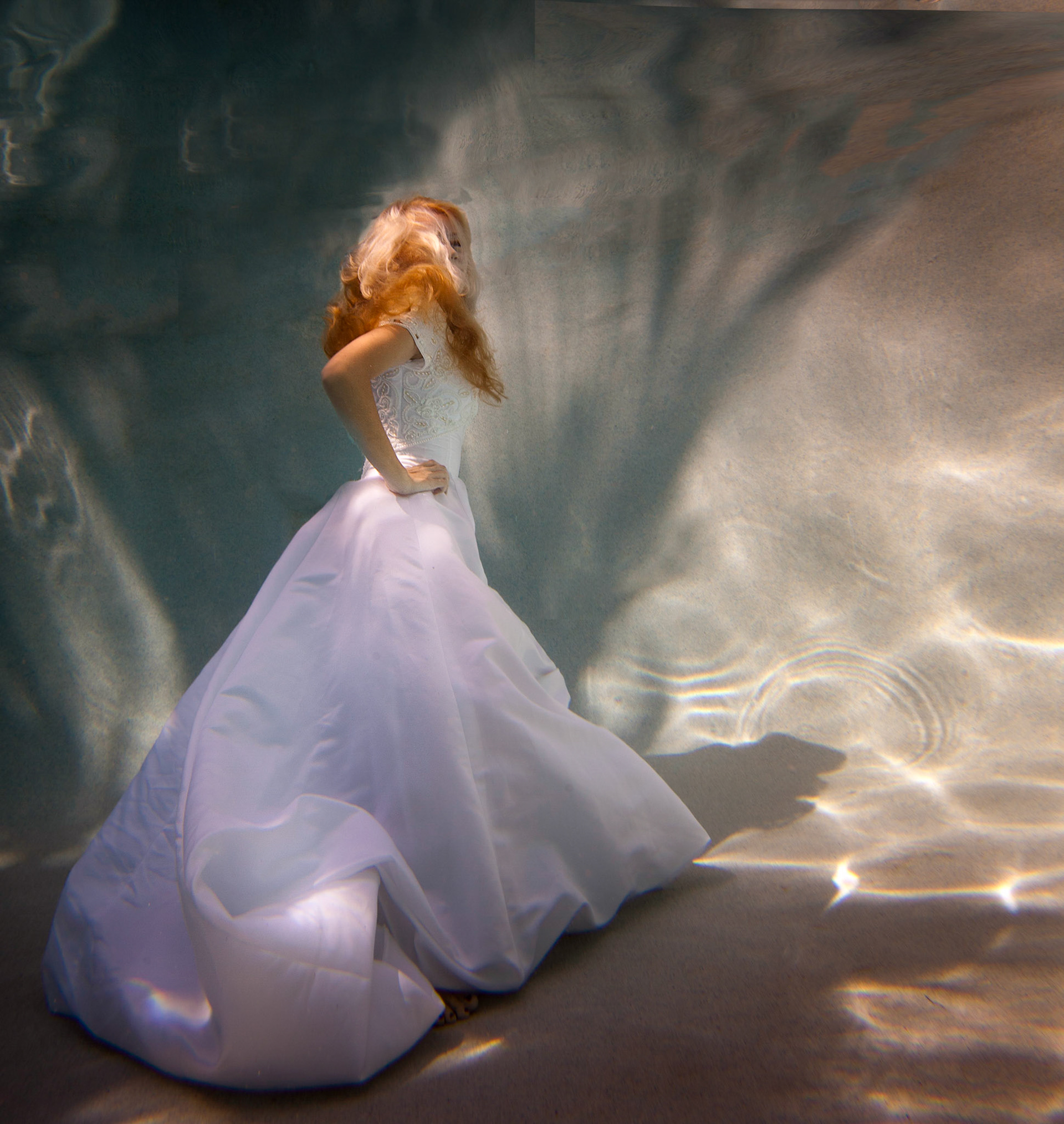 6201-Bridal art trash the dress style.  Rachael in a wedding dress modelling as only she can. This was her first project underwater and she did a fabulous job. We took these images in a pool. In all of these images both Rachael and photographer are underwater.