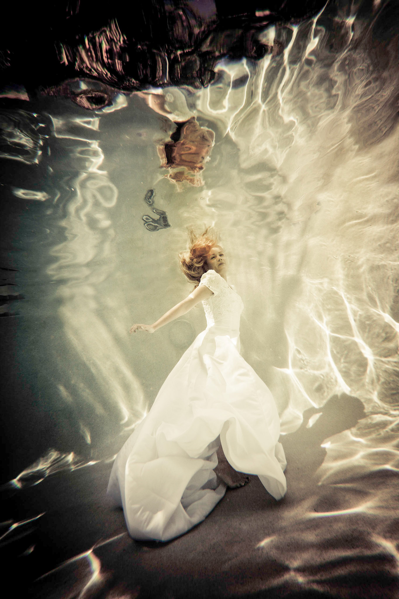 6200-Bridal art trash the dress style.  Rachael in a wedding dress modelling as only she can. This was her first project underwater and she did a fabulous job. We took these images in a pool. In all of these images both Rachael and photographer are underwater.