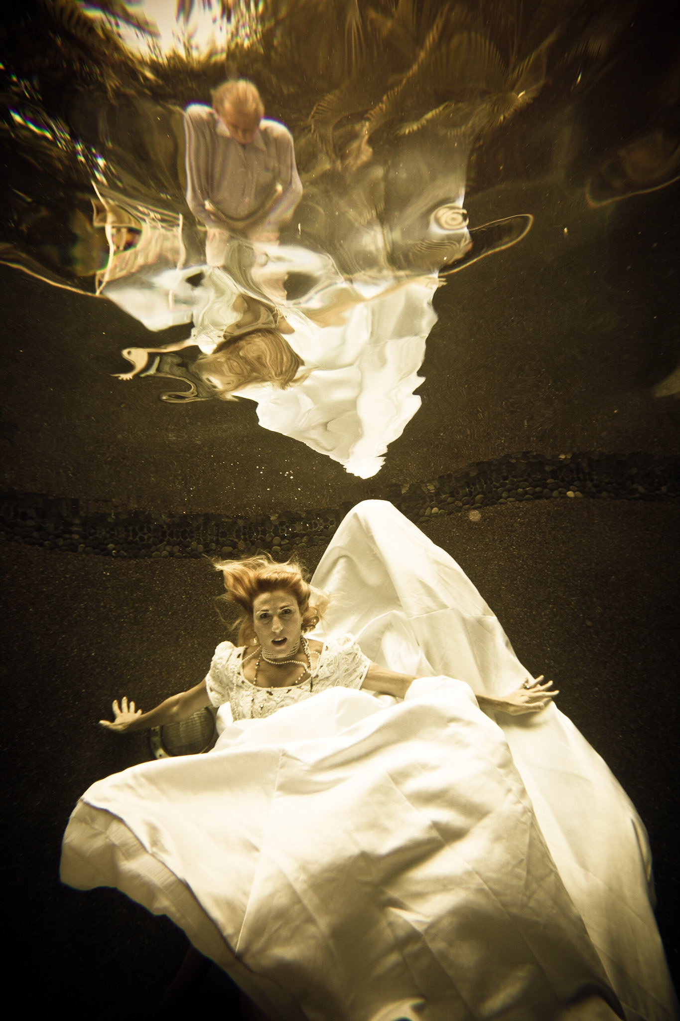 7919-Bridal art trash the dress style.Helen in her wedding dress taking the plunge. We took these images in Helen's pool, love the dark finish. In all of these images both the model and photographer are underwater.
