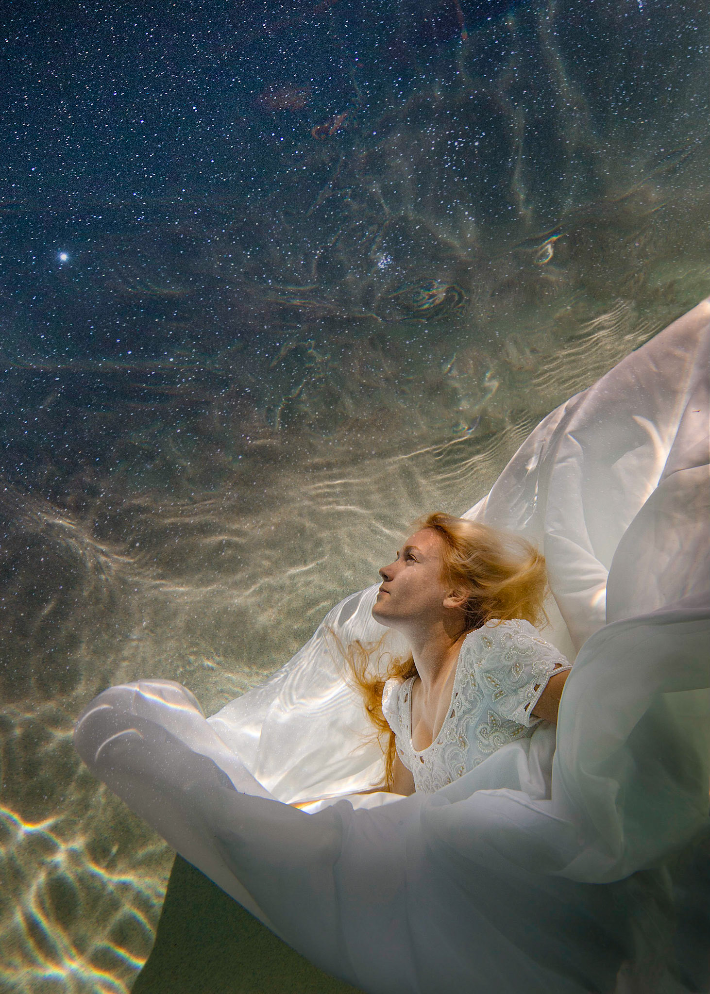6203-Bridal art trash the dress style.  Rachael in a wedding dress modelling as only she can. This was her first project underwater and she did a fabulous job. We took these images in a pool. In all of these images both Rachael and photographer are underwater.