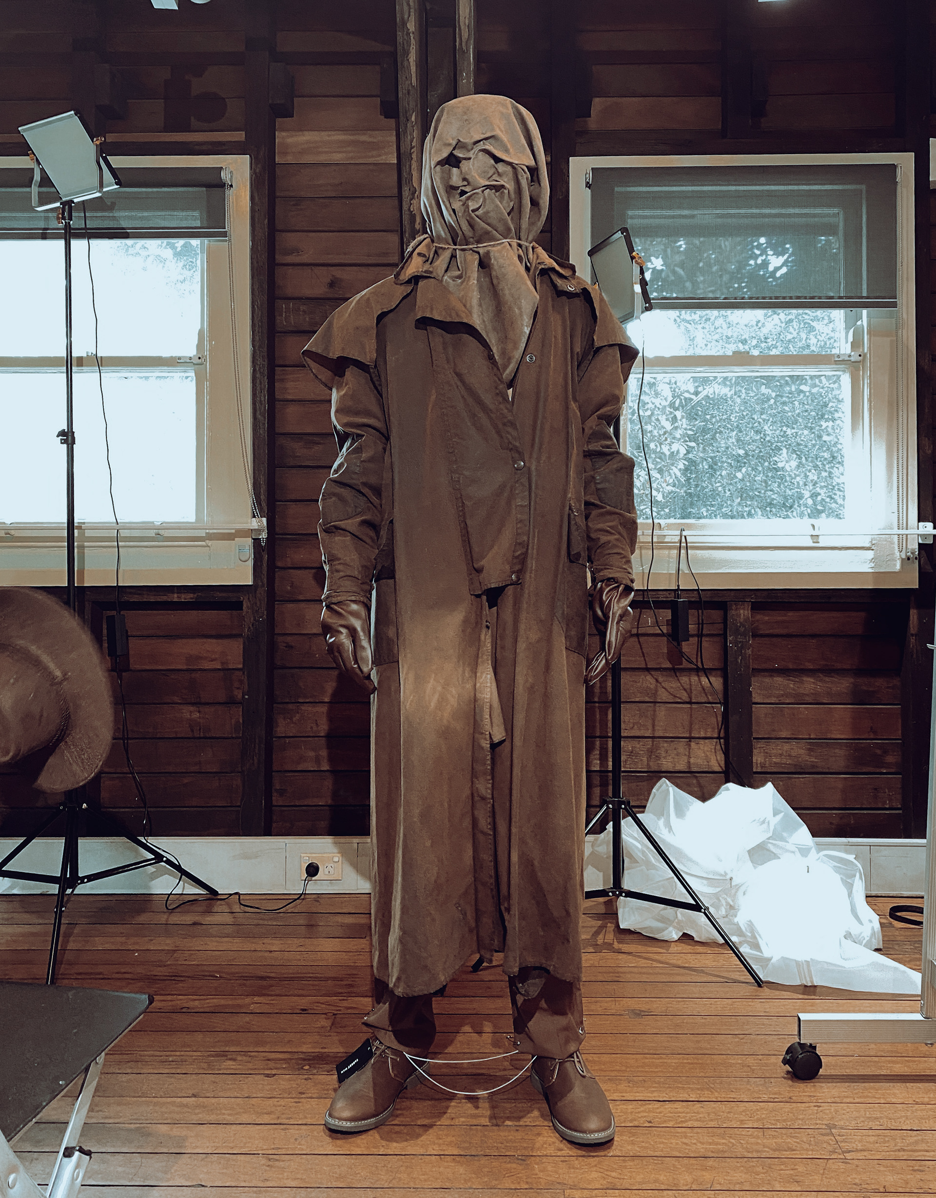 hooded masked man in brown weathered coat costume