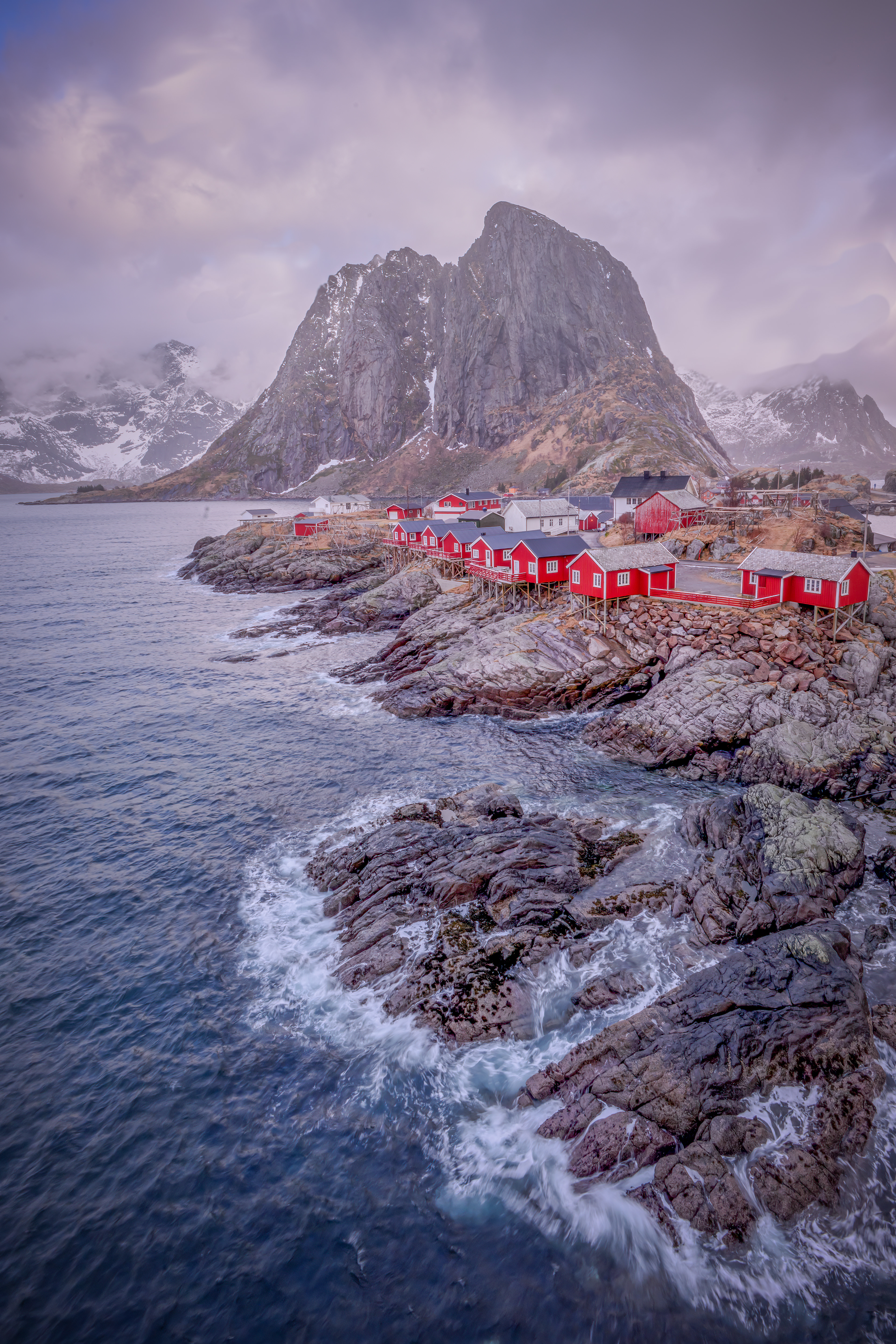 Standing on the Hamnøy Bridge, I photographed the traditional red Rorbuer (fishing cabins) alongside the majestic Festhelltinden Mountain, with waves crashing against the rocks below. This spot offers an incredible view of the stunning scenery—provided the wind isn't howling with gusts exceeding 80 km/h.