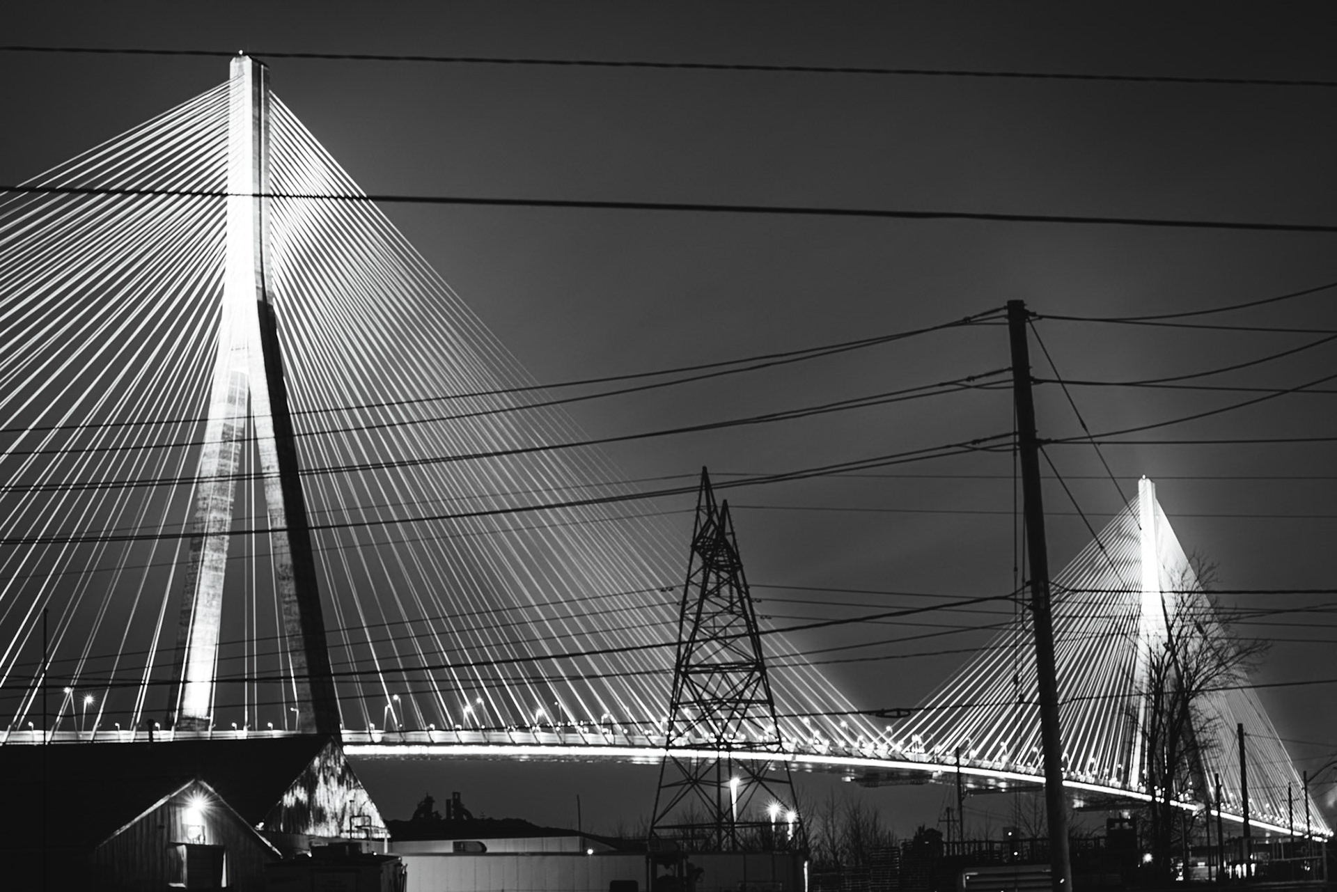 Monolithic Noir study of the Gordie Howe International Bridge, rendered with maximum depth of field to include foreground industrial grit. A.M. Stone | Archival Stone Photography
