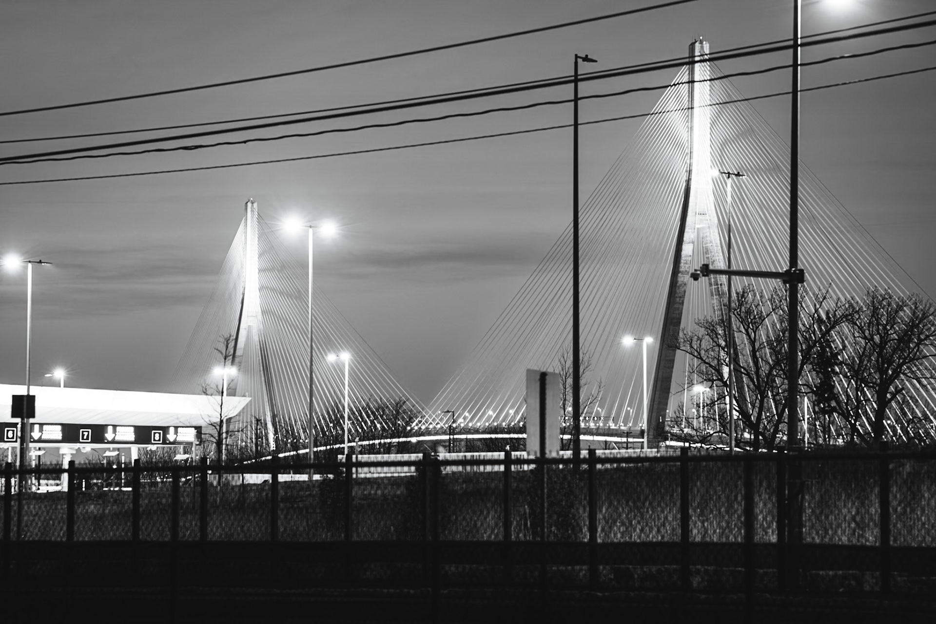 Border Crossing: Iron Witness series. Long-exposure study of international patrol lanes at twilight, capturing the signatures of restriction and the American POV on the Detroit-Windsor frontier.
