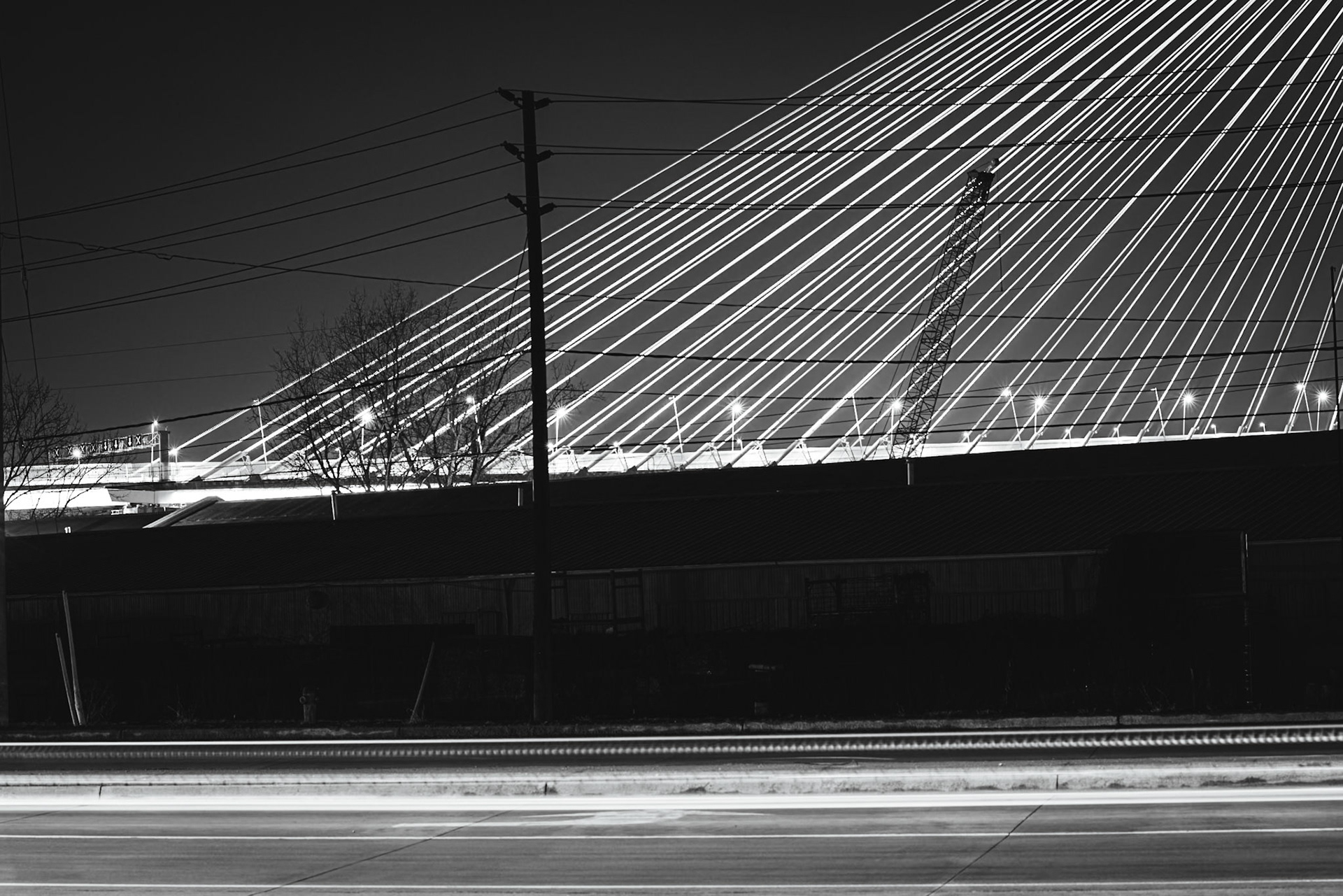 Monolithic Noir study of the Gordie Howe International Bridge, rendered with maximum depth of field to include foreground industrial grit. A.M. Stone | Archival Stone Photography
