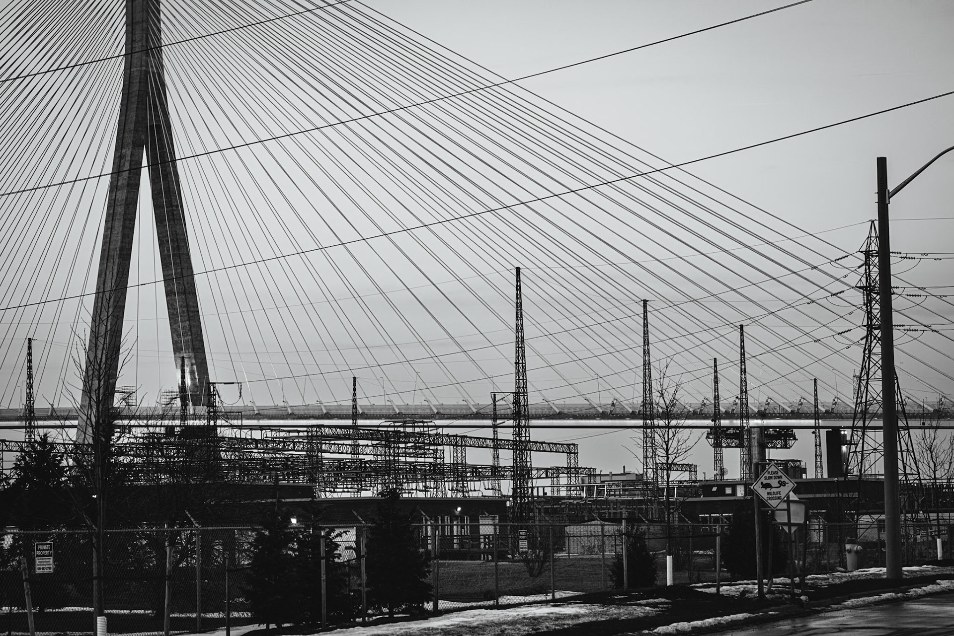 Monolithic Noir study of the Gordie Howe International Bridge, rendered with maximum depth of field to include foreground industrial grit. A.M. Stone | Archival Stone Photography