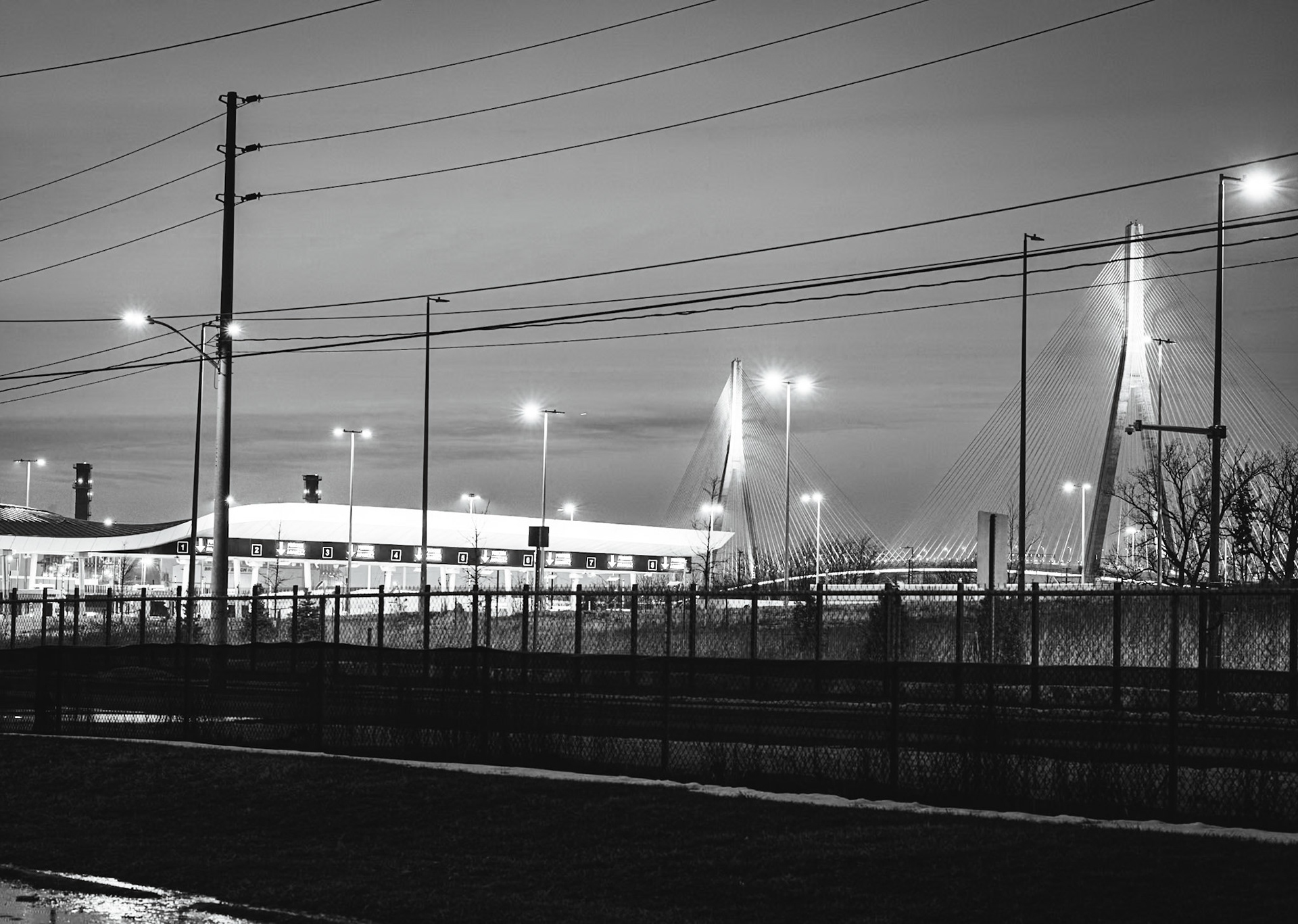 Border Crossing: Iron Witness series. Long-exposure study of international patrol lanes at twilight, capturing the signatures of restriction and the American POV on the Detroit-Windsor frontier.