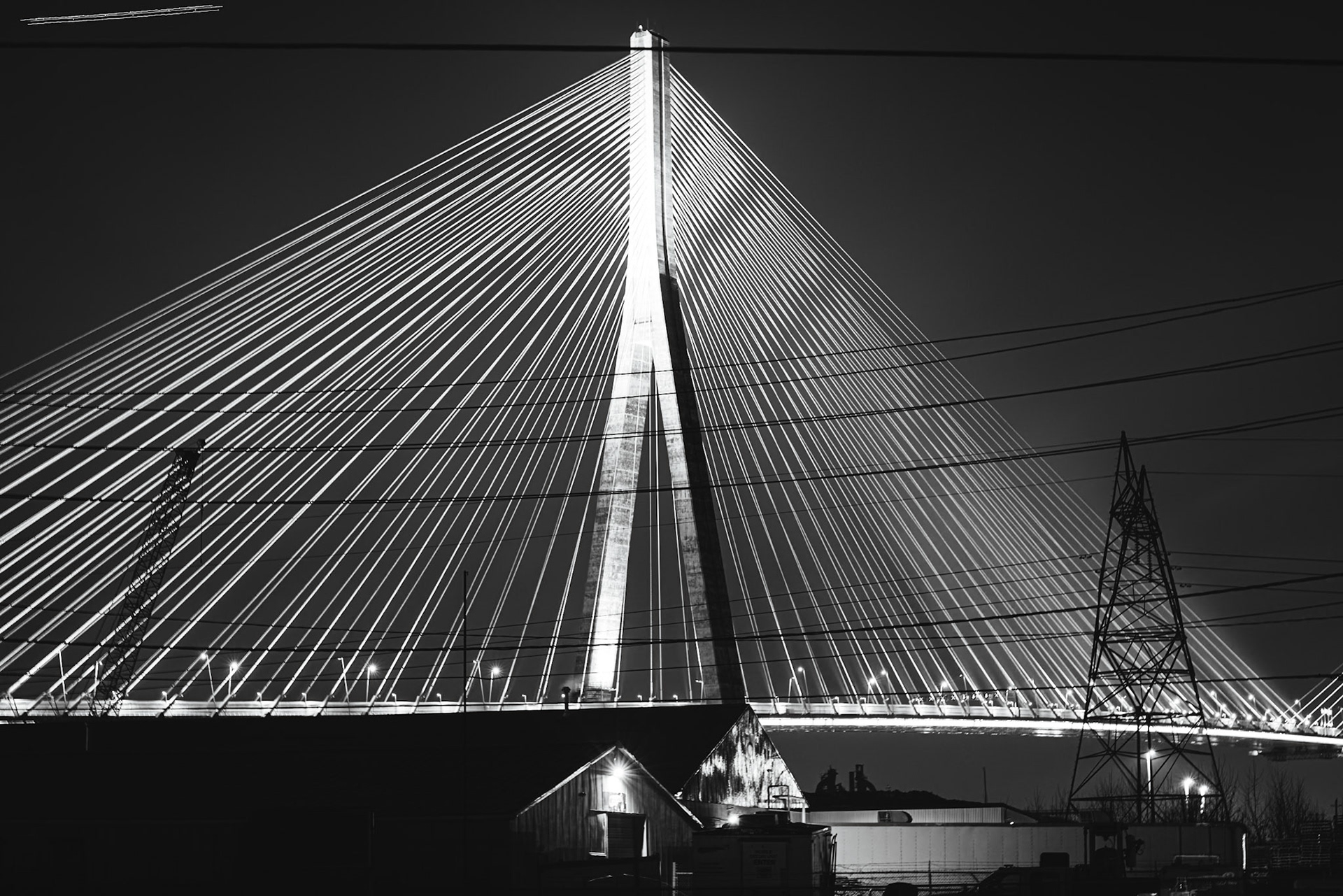 Monolithic Noir study of the Gordie Howe International Bridge, rendered with maximum depth of field to include foreground industrial grit. A.M. Stone | Archival Stone Photography
