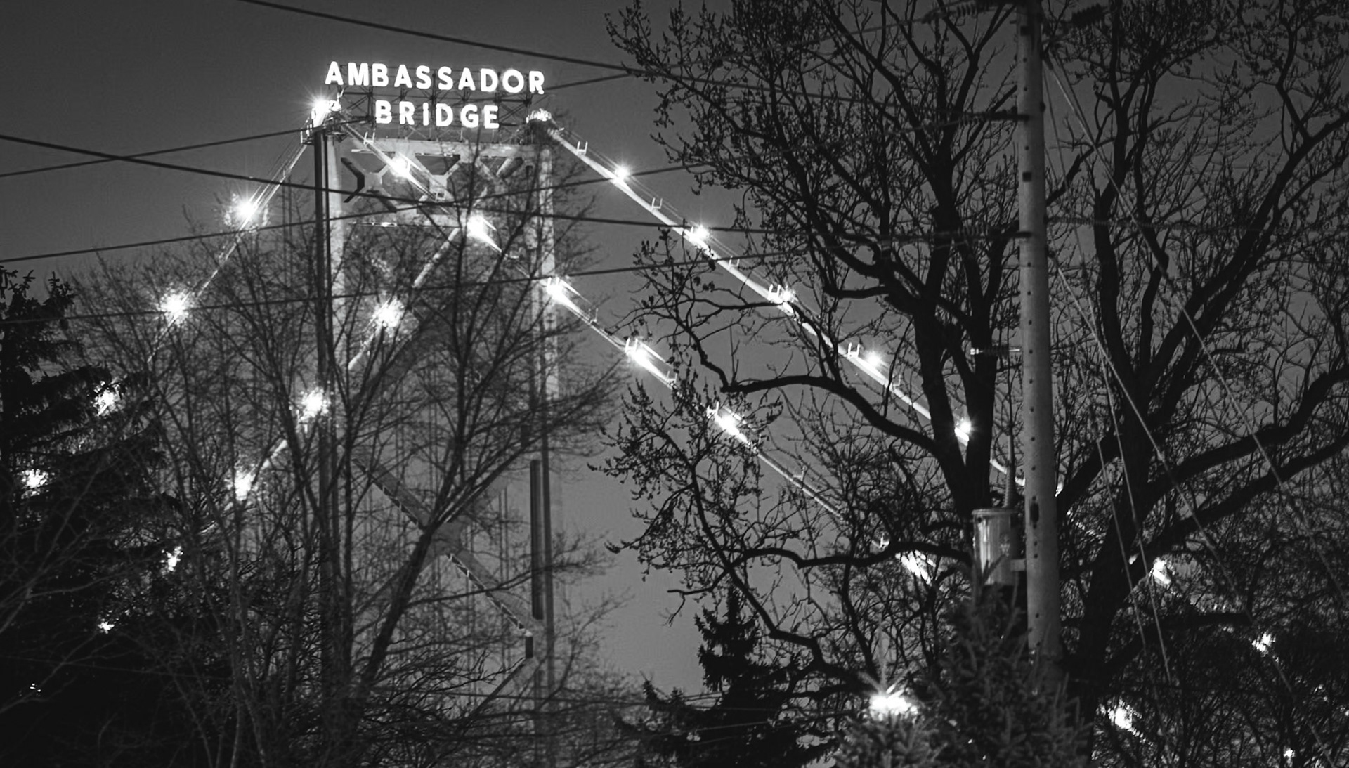 Monolithic Noir study of the Ambassador International Bridge, rendered with maximum depth of field to include foreground industrial grit. A.M. Stone | Archival Stone Photography