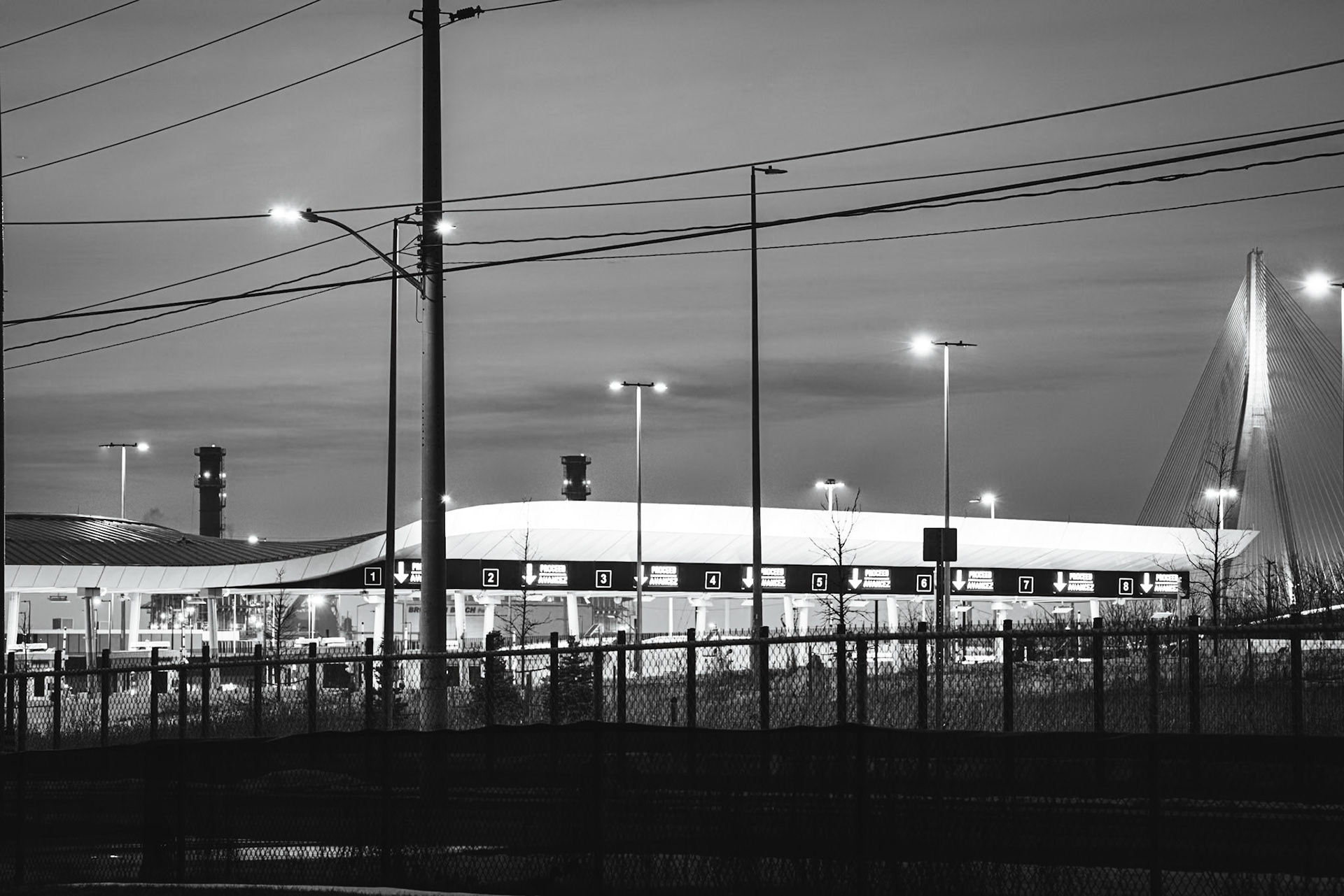 Border Crossing: Iron Witness series. Long-exposure study of international patrol lanes at twilight, capturing the signatures of restriction and the American POV on the Detroit-Windsor frontier.