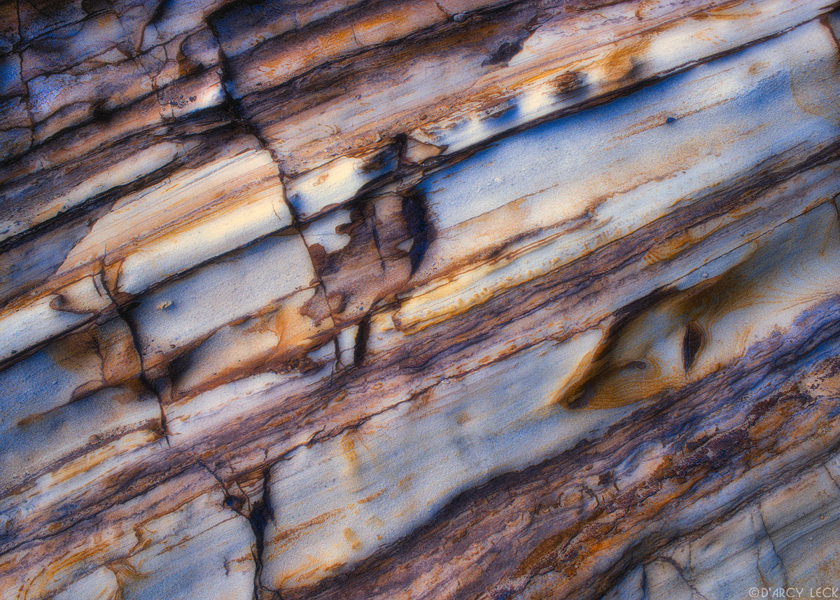 Striations and cracks in tan stained sandstone, Point Reyes National Seashore, California