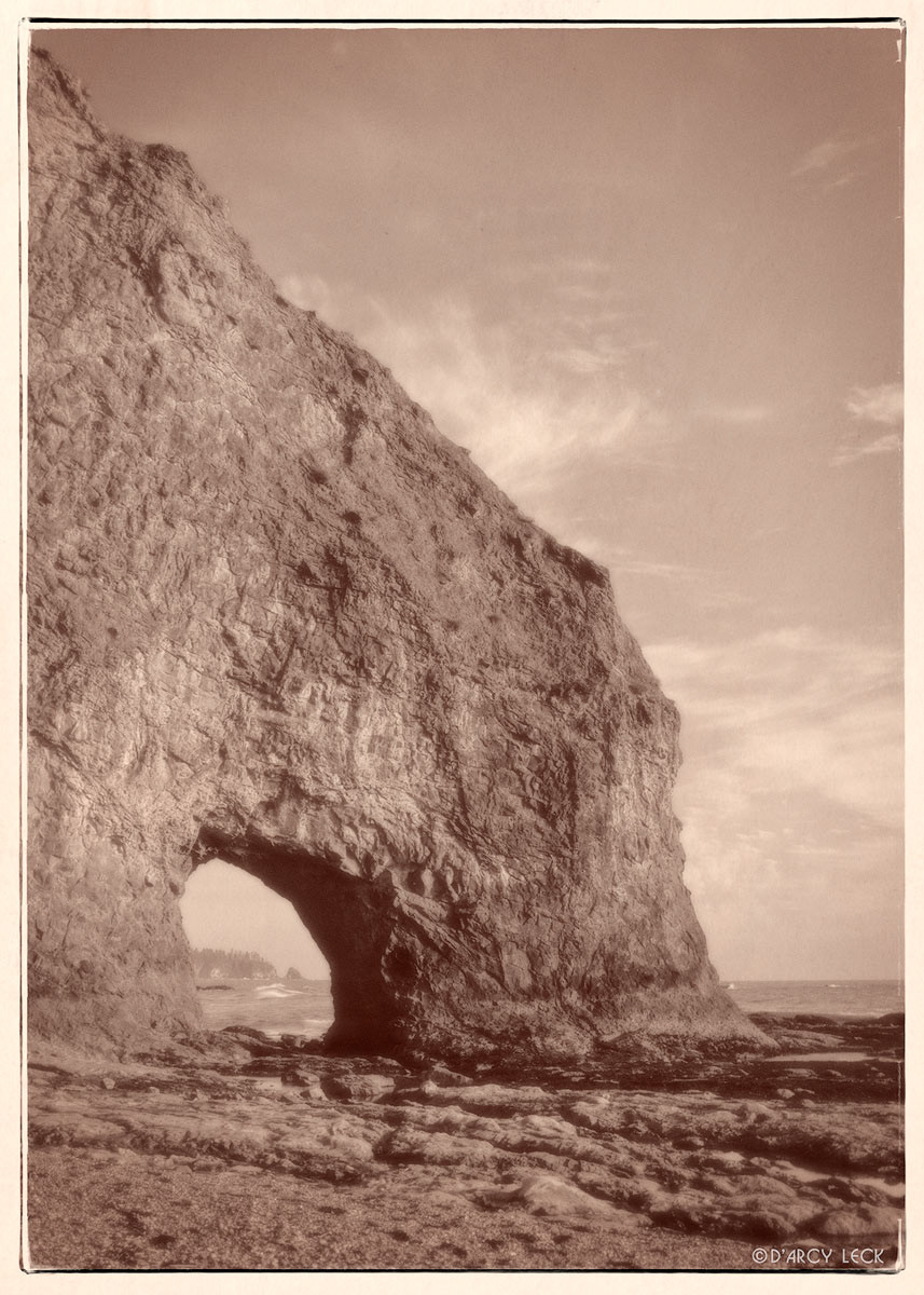 Hole in cliff wall along shore of Rialto Beach, Washington