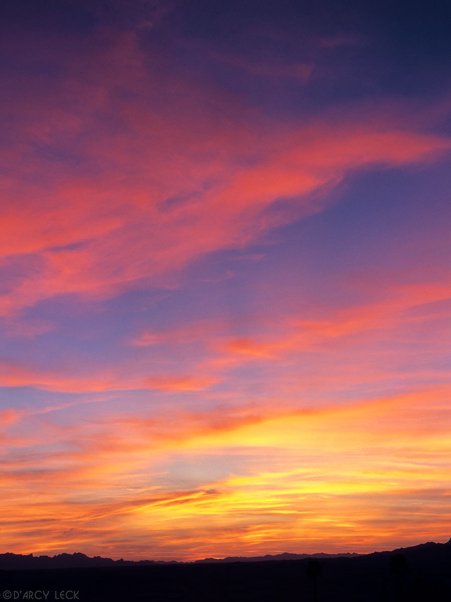 High clouds painted in dusk colors over mountains near Lake Havasu, Arizona