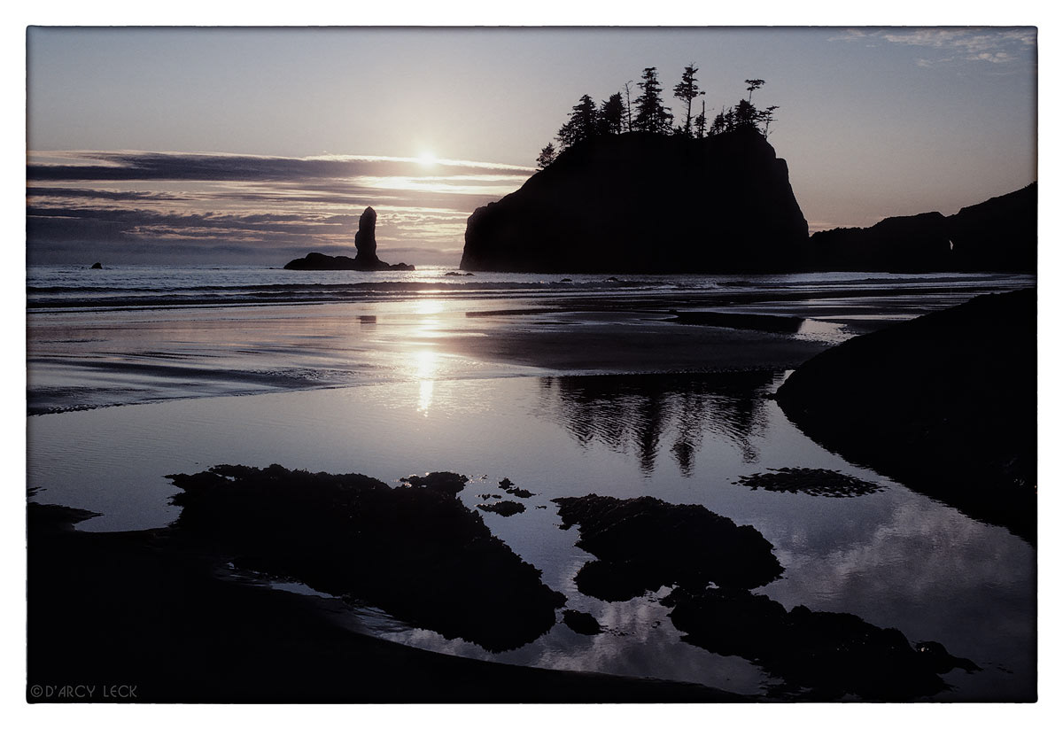 Setting sun reflects in water at low tide along Second Beach, Washington