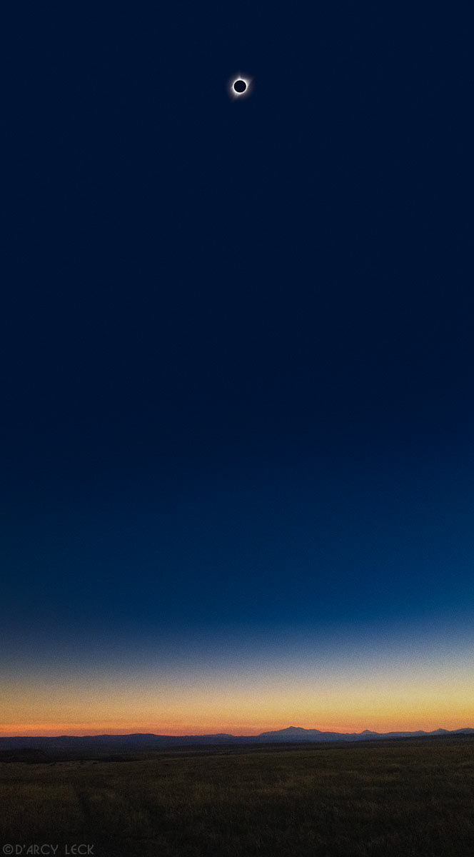totality phase over darkened Wyoming rangeland during total solar eclipse with Laramie Peak in distance