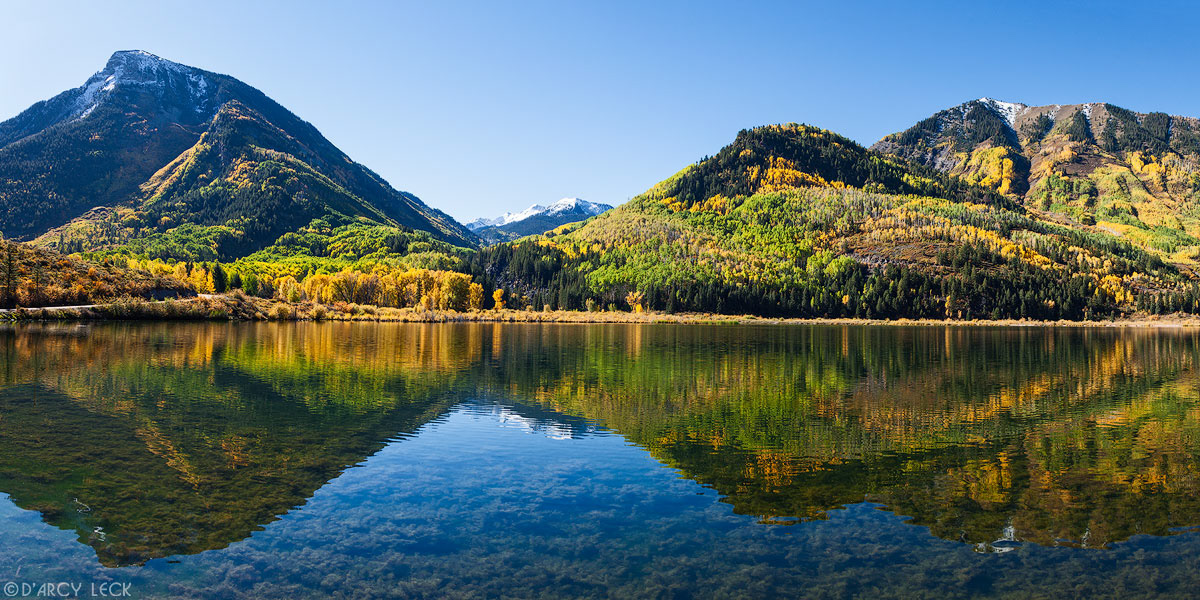 Mountains, including Whitehouse Mountain, and forest reflect in Beaver Lake on a early Autumn morning, Colorado