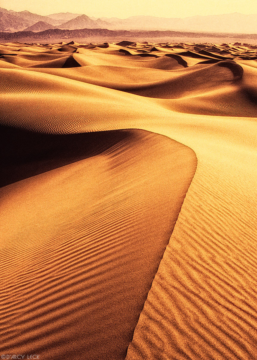 Sand dunes undulate toward distant Funeral Mountains, Death Valley National Park, California
