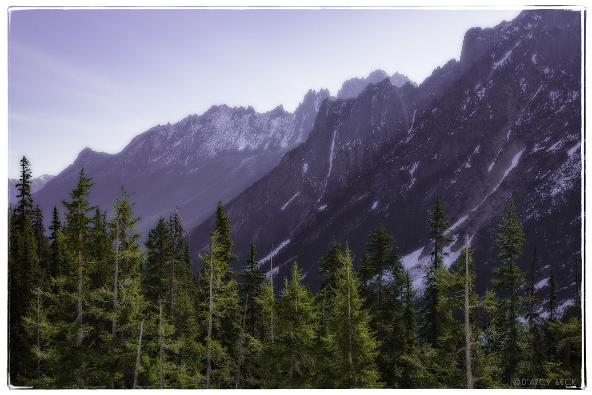 Morning sunlight glows behind the Snagtooth Ridge in the Cascade Range mountains, Washington