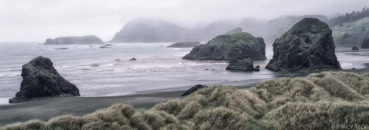 Sea stacks along coastal beach and beach grass at Meyers Creek Beach River Park along the Oregon coast