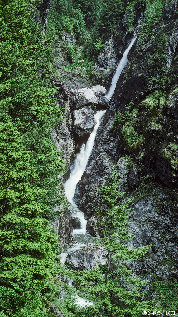 Waterfall plunges in narrow canyon in the Cascade Range mountains, Washington