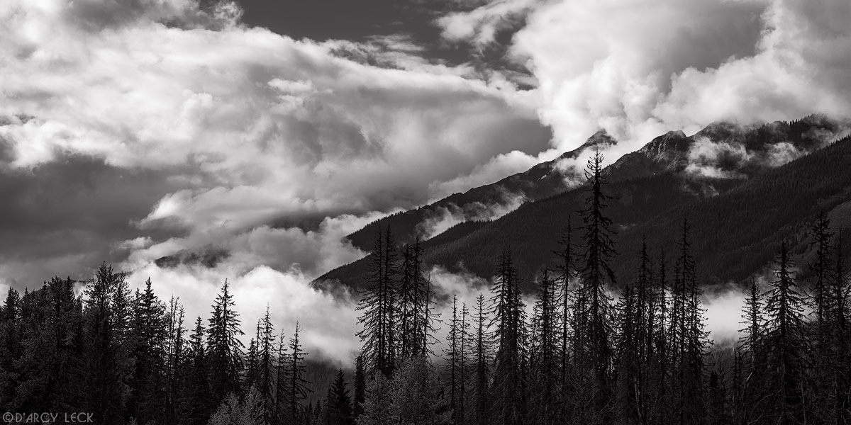 Storm clouds linger around the peaks and valleys of the Hermit Range in Glacier National Park, British Columbia, Canada
