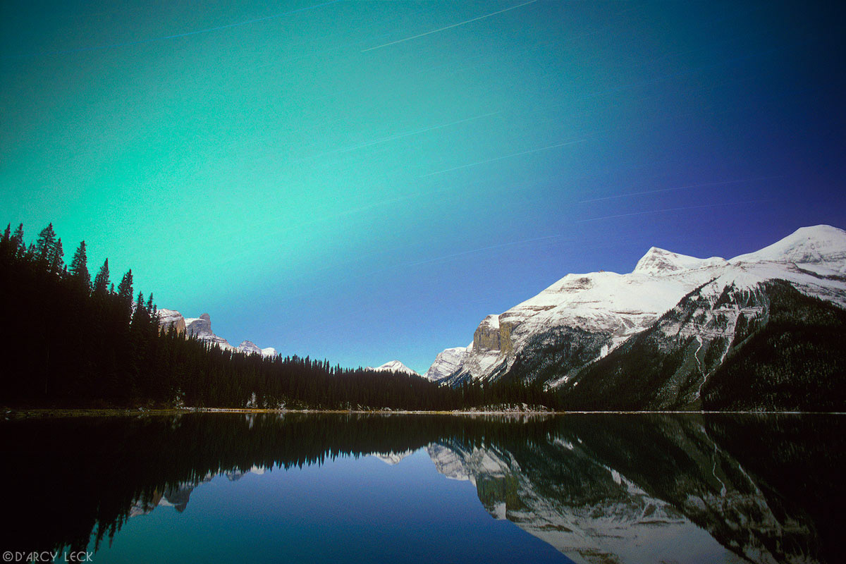 Star trails and Northern Lights (aurora borealis) above Mount Charlton and Fisherman's Bay on Maligne Lake, Jasper National Park, Alberta, Canada