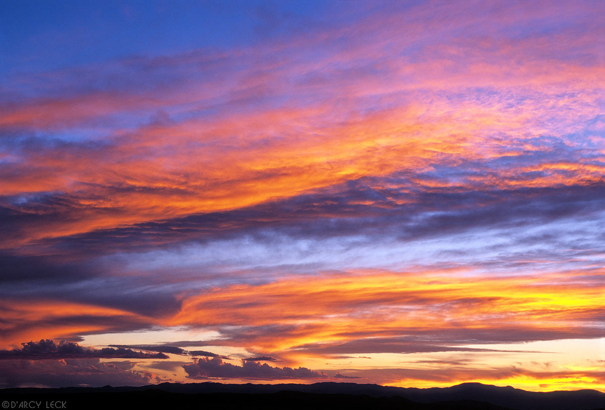 Clouds painted in sunset colors at dusk, over the Jemez Mountains of North Central New Mexico, USA
