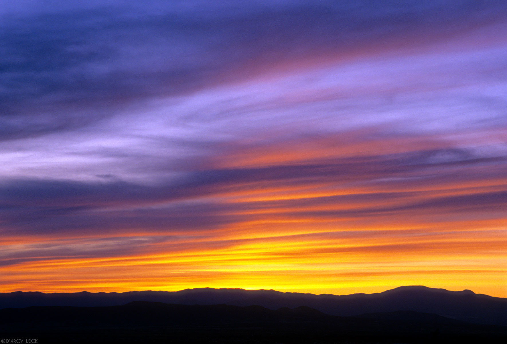 Sunset illuminates clouds over Jemez mountains in north central Rio Grande Valley, New Mexico, USA